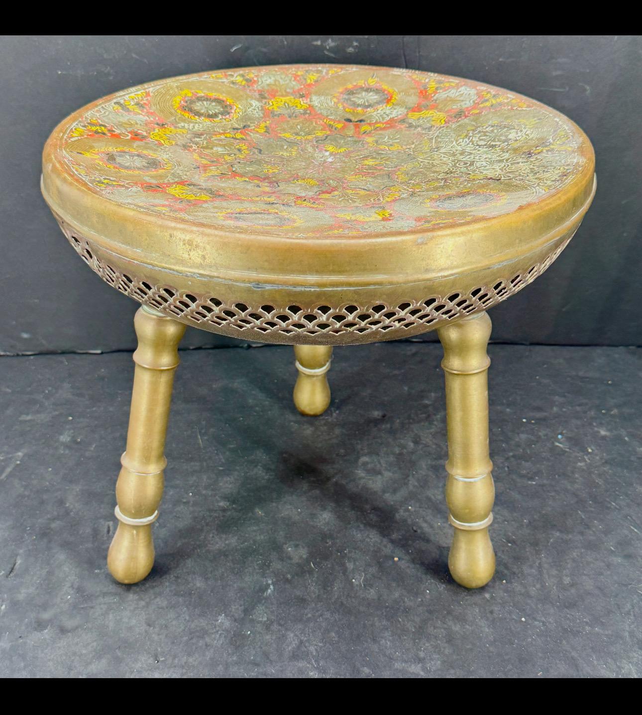 Schöner dreibeiniger Hocker, Tisch oder Pflanzenständer aus Messing im Vintage-Stil mit einem tollen Emaille-Design auf der Sitzfläche. Burgunderrot ziert den äußeren Rand und ist die Grundfarbe. Weiße, hellblaue, dunkelblaue, goldene, grüne und