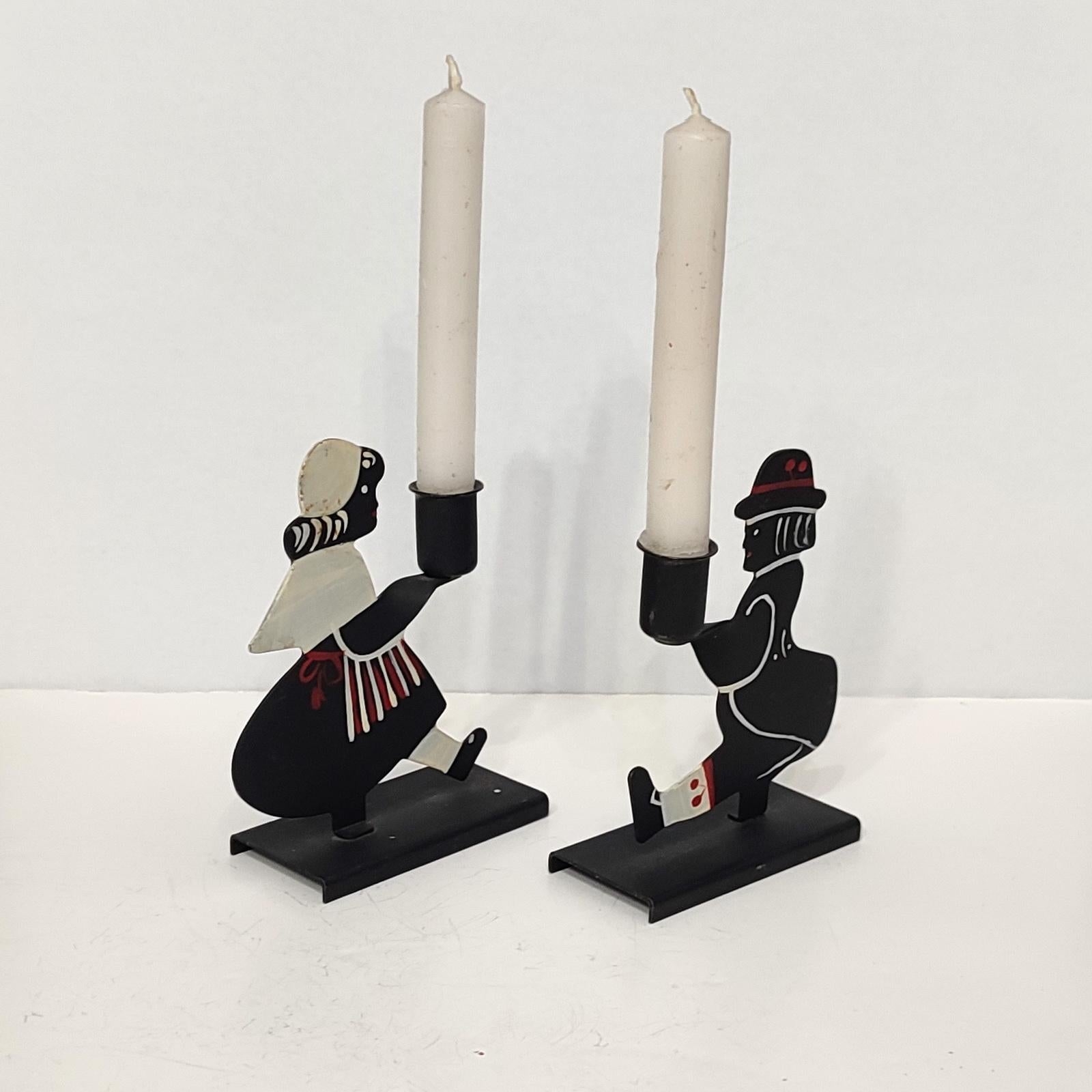 Lovely pair of candlesticks depicting a couple dressed in folk clothes, each holding a sconce. Small, for 1 cm candles, perfect for a private dinner for two. Each marked and dated 1960 on the bottom.
Good overall condition, minor fading to the