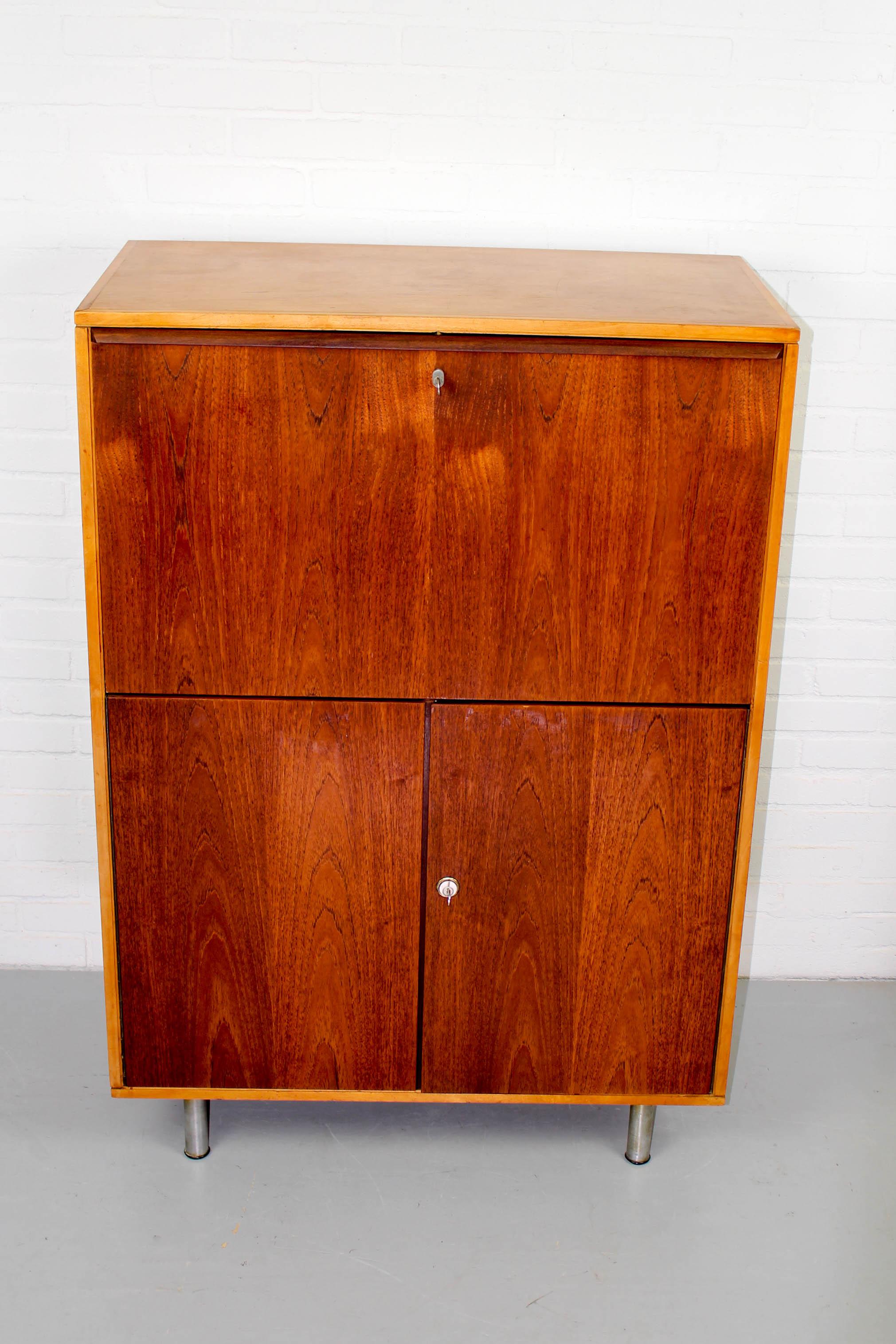 Rare Cees Braakman desk and cabinet with birch body and teak doors with the original metal legs and inner desk organizer. In very good original condition . Locks works and keys are available. Dimensions: 118cm H, 81cm W and 43 cm D.