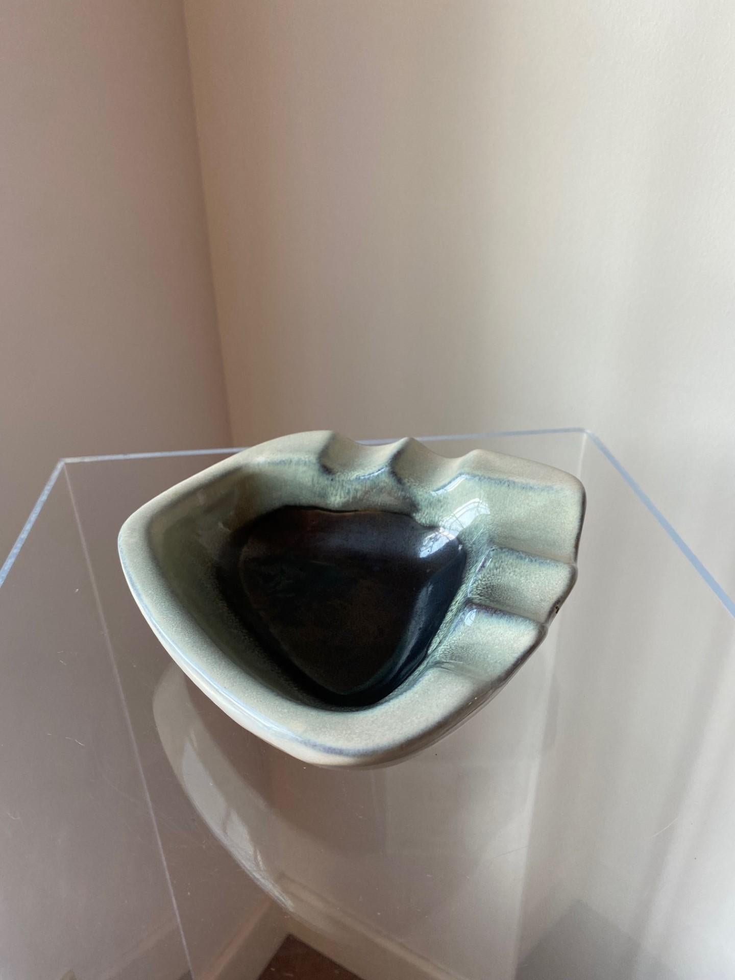 Beautiful ceramic sculptural ashtray in an array of gradient blue glaze. Although originally an ashtray, this piece transcends to a decorative piece or sculpture. With a morphic shape that wraps around ridges that envelop a deep color that goes from