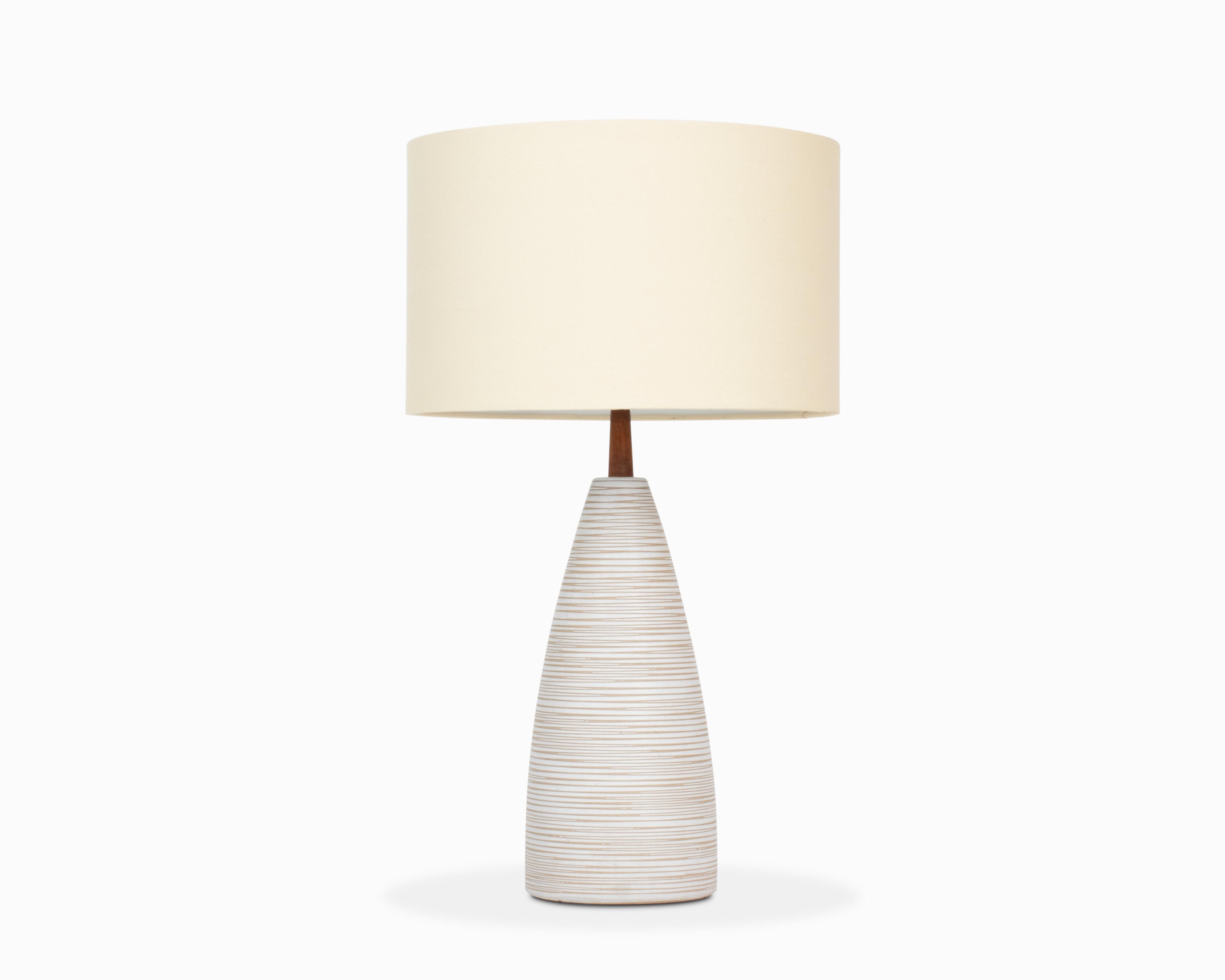 Here is a beautiful ceramic table lamp by Jane and Gordon Martz / Marshall Studios. Model M53-28-1. It features a unique conical shape in a neutral matte white color with elegant striped incising. The lamp is in excellent shape with no noteworthy