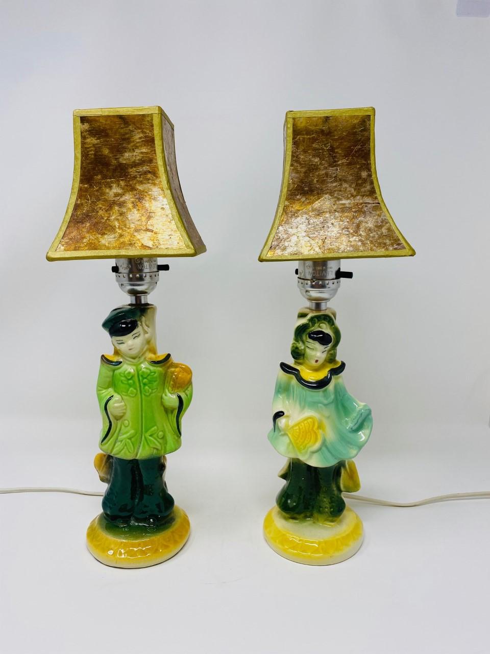 Beautifully charming set of chinoiserie table lamps. This set consists of two vintage lamps (1950’s) figuratively evoking a male and a female figure each. The ceramic sculptures delightfully present colors in a variety of greens and yellows with
