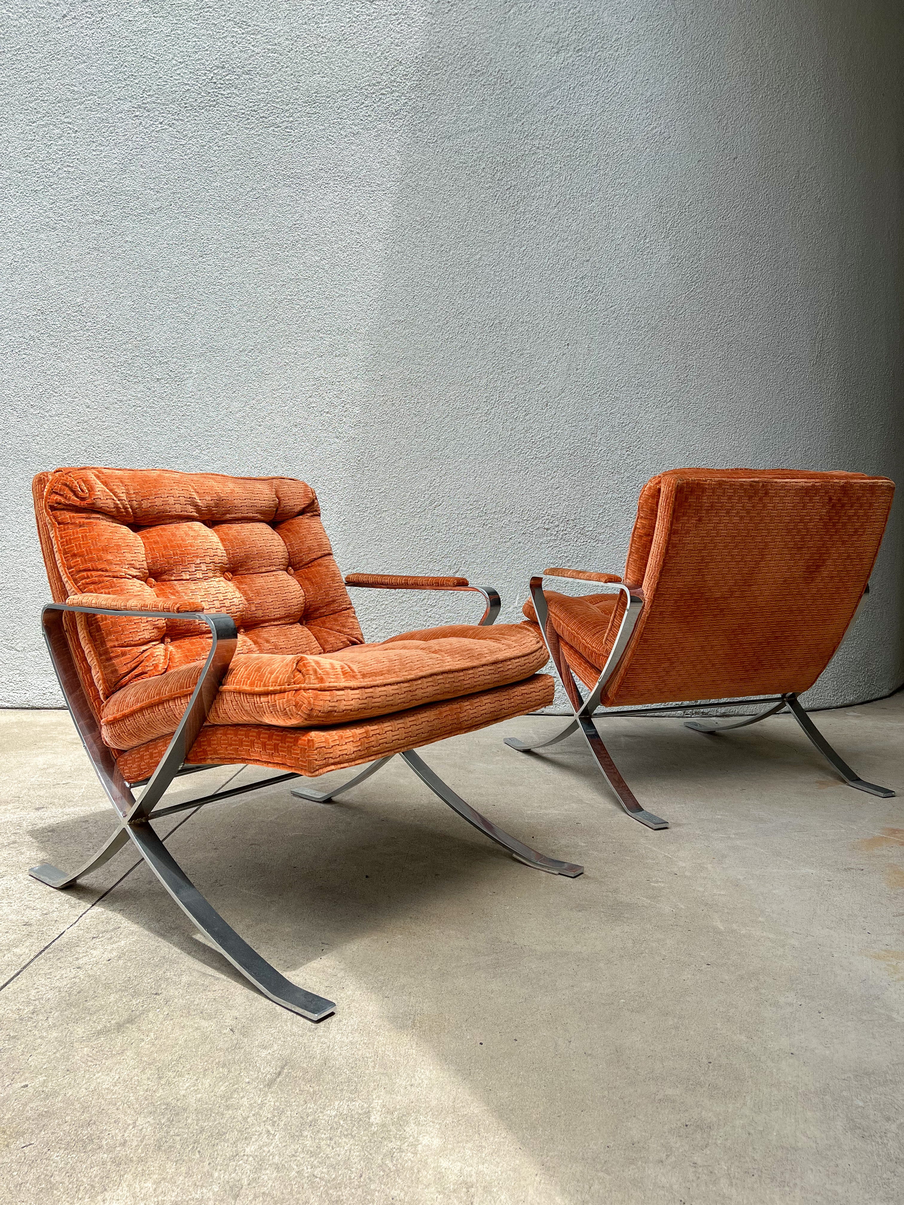 Pair of Mid-Century Modern lounge chairs circa 1970s. With a recently polished flat steel chrome frame and original burnt orange velvet upholstery, these chairs are a combination of two staple designers: Milo Baughman and Mies Van der Rohe's