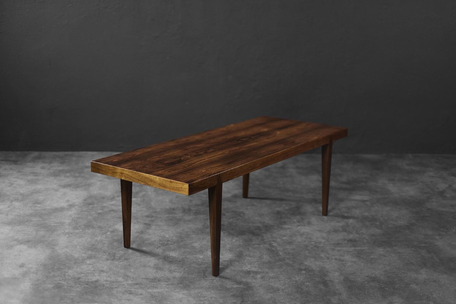 Cette élégante table basse a été conçue par Severin Hansen pour le fabricant danois Haslev Møbelsnedskeri dans les années 1960. Il est fini avec un magnifique bois de rose d'une teinte sombre et intense avec un grain distinct. La couleur brun foncé