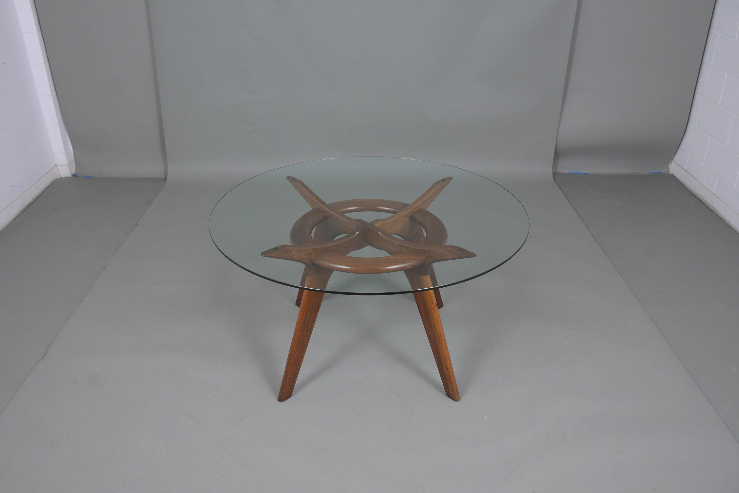 This vintage mid-century modern dining table has been professionally restored by our expert craftsmen and is in great condition. The table features a 3/8