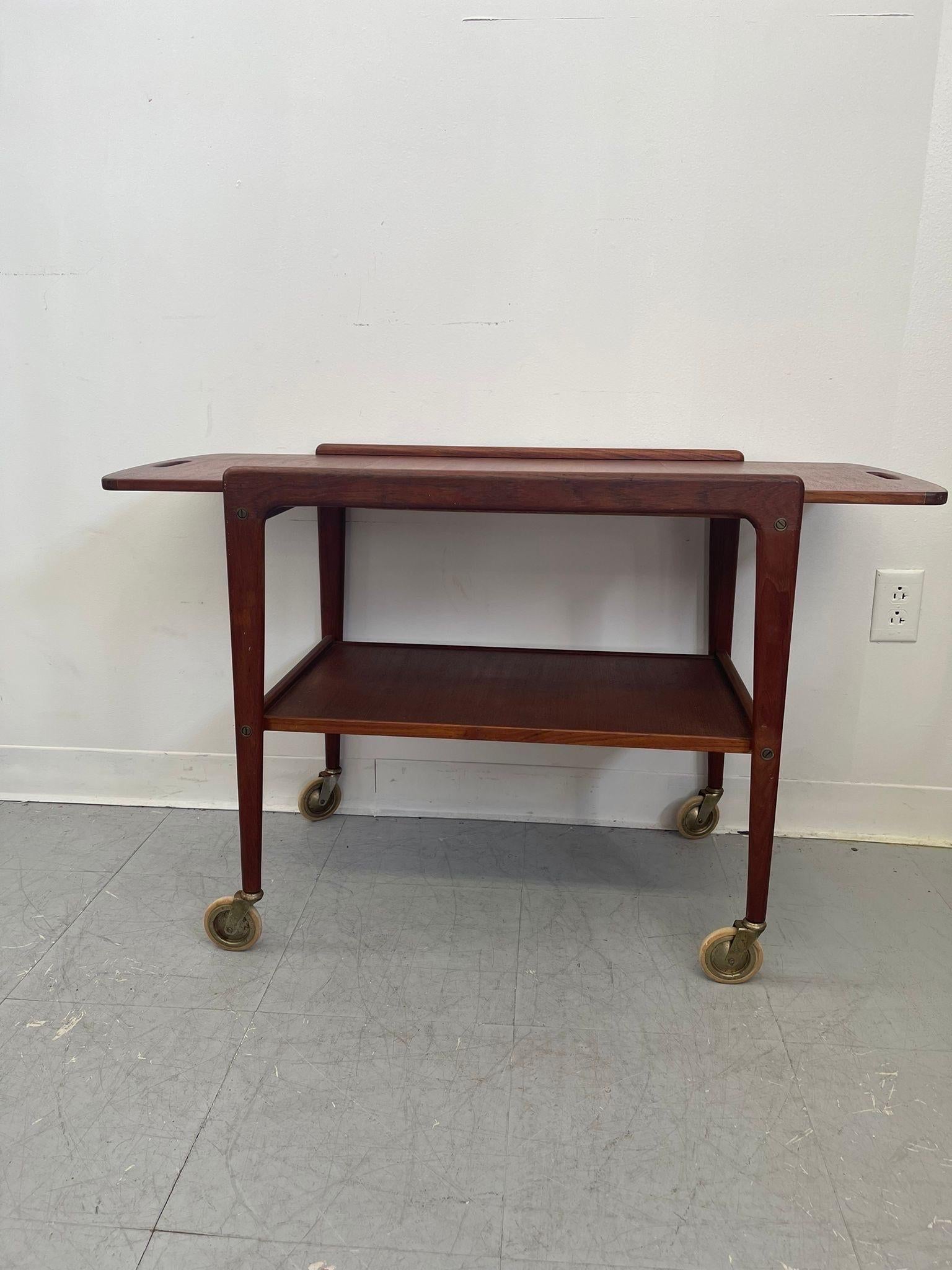 Bar Cart on casters. Possibly Teak. Sleek Danish modern design. Circa 1960s/1970s. Vintage Condition Consistent with Age as Pictured.

Dimensions. 39 1/2 W ; 16 1/2 D ; 24 H