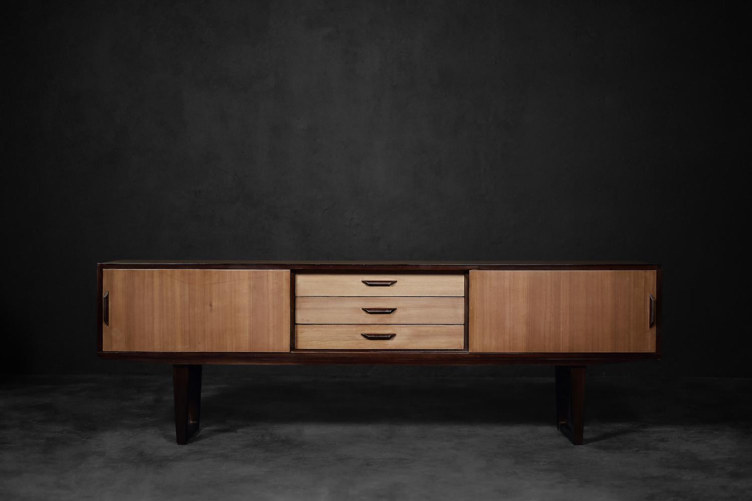This classic sideboard was made in Denmark during the 1970s. It is made of extremely interesting and rare exotic wood. The wood grain is delicate and harmonizes with the overall aesthetics of the furniture. The sideboard has three drawers in the