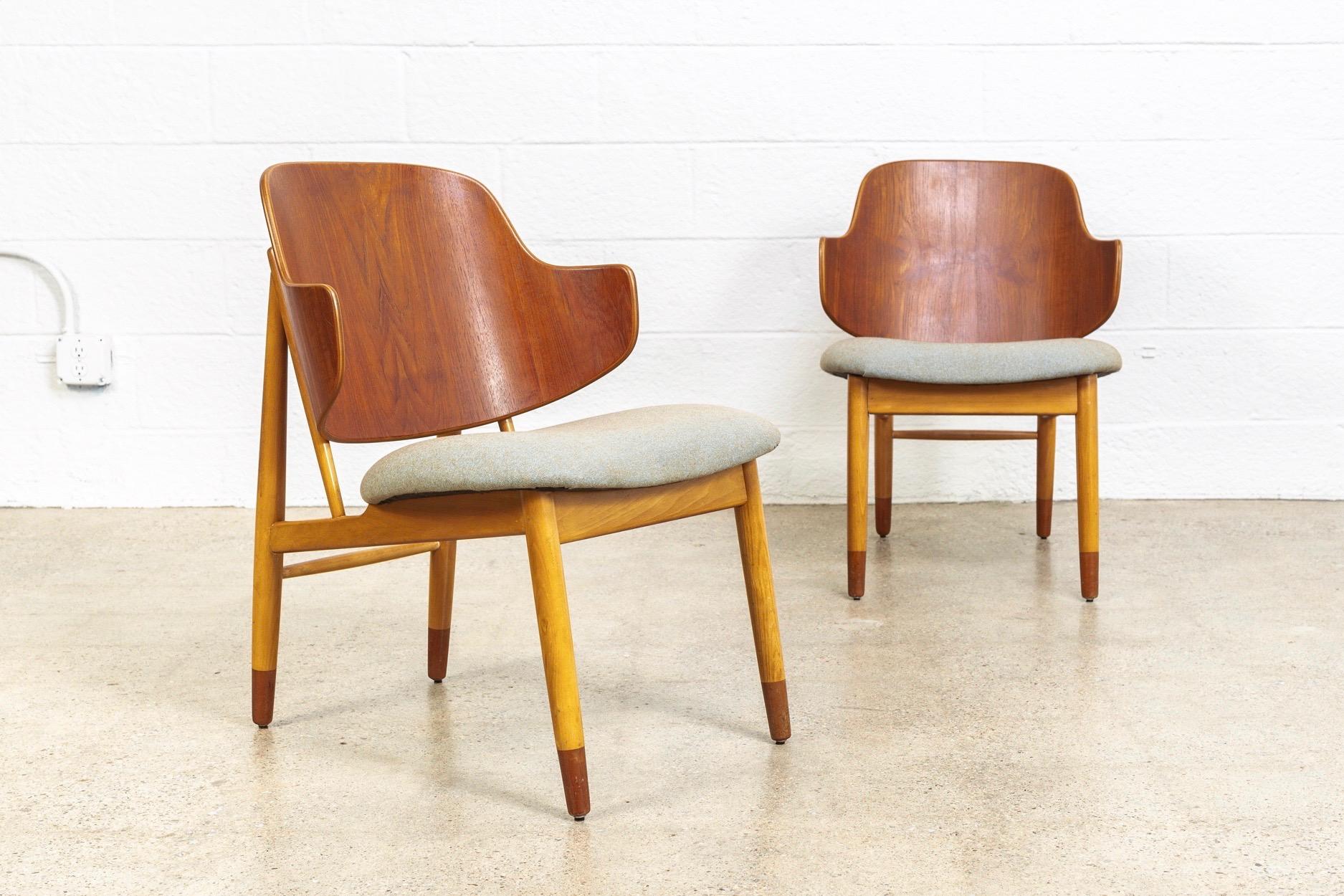 This pair of vintage midcentury Danish modern “Penguin” chairs designed by Ib Kofod Larsen in the early 1950s, were made in Denmark, circa 1960. The iconic Scandinavian Modern design features clean, Minimalist lines and gentle angles. The signature