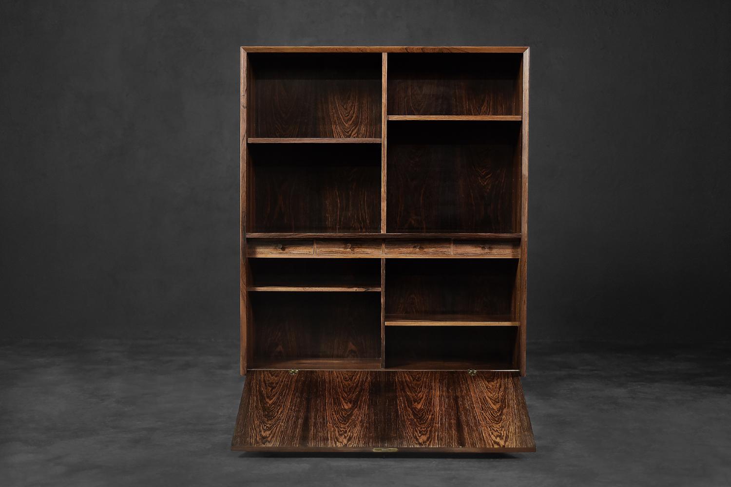 This cabinet was designed during the 1960s by Erik Brouer for the Danish manufacturer Brouer Møbelfabrik. It is made of rosewood with rich graining. The bookcase has four shelves whose height can be adjusted. Below it has a vertically closed bar