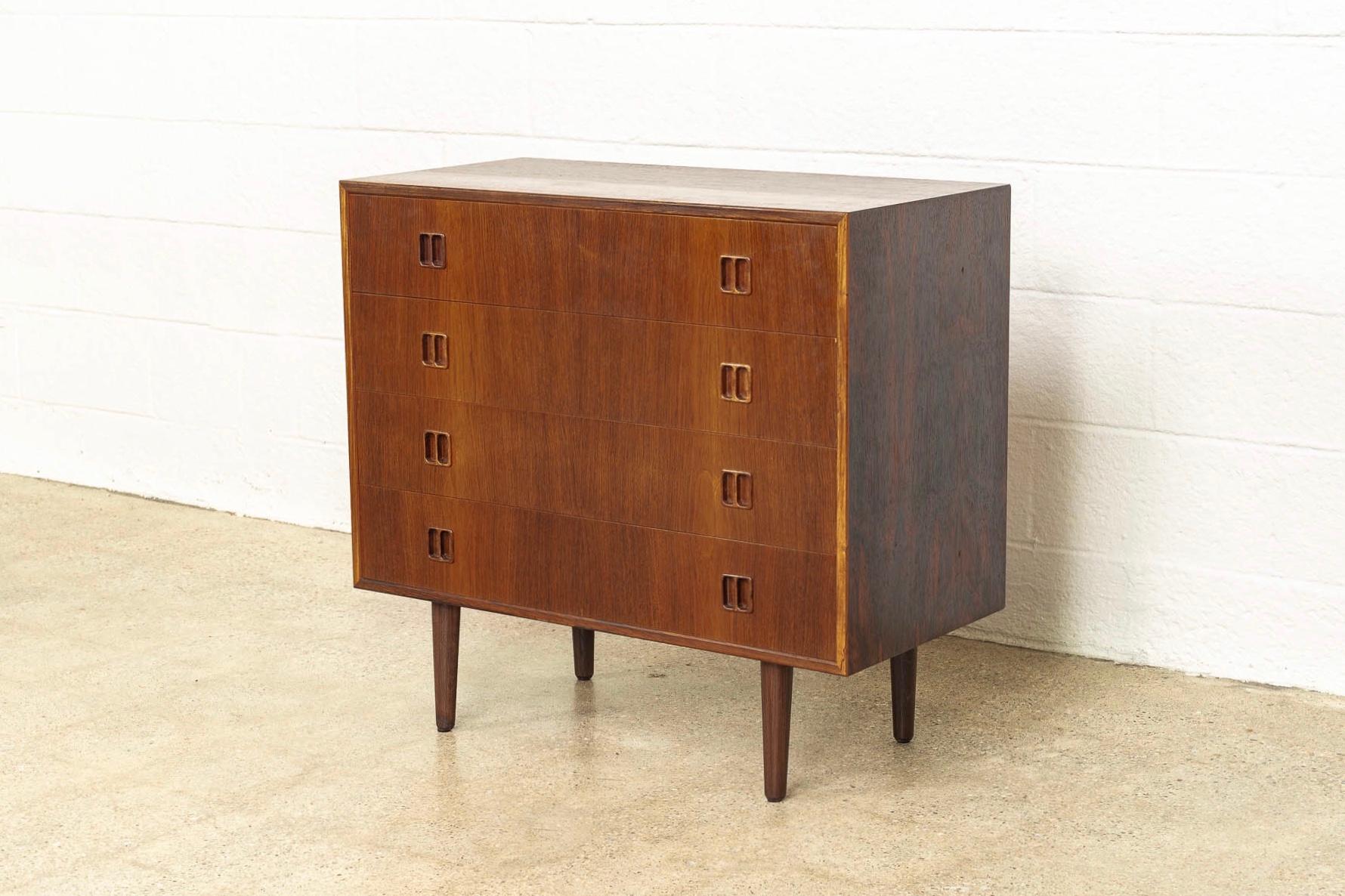 This exceptional vintage midcentury Danish modern sideboard buffet was made in Denmark circa 1960. Well-crafted from rosewood, it features beautiful natural wood grain, sculpted double wooden drawer pulls and tapered legs. The four dovetailed