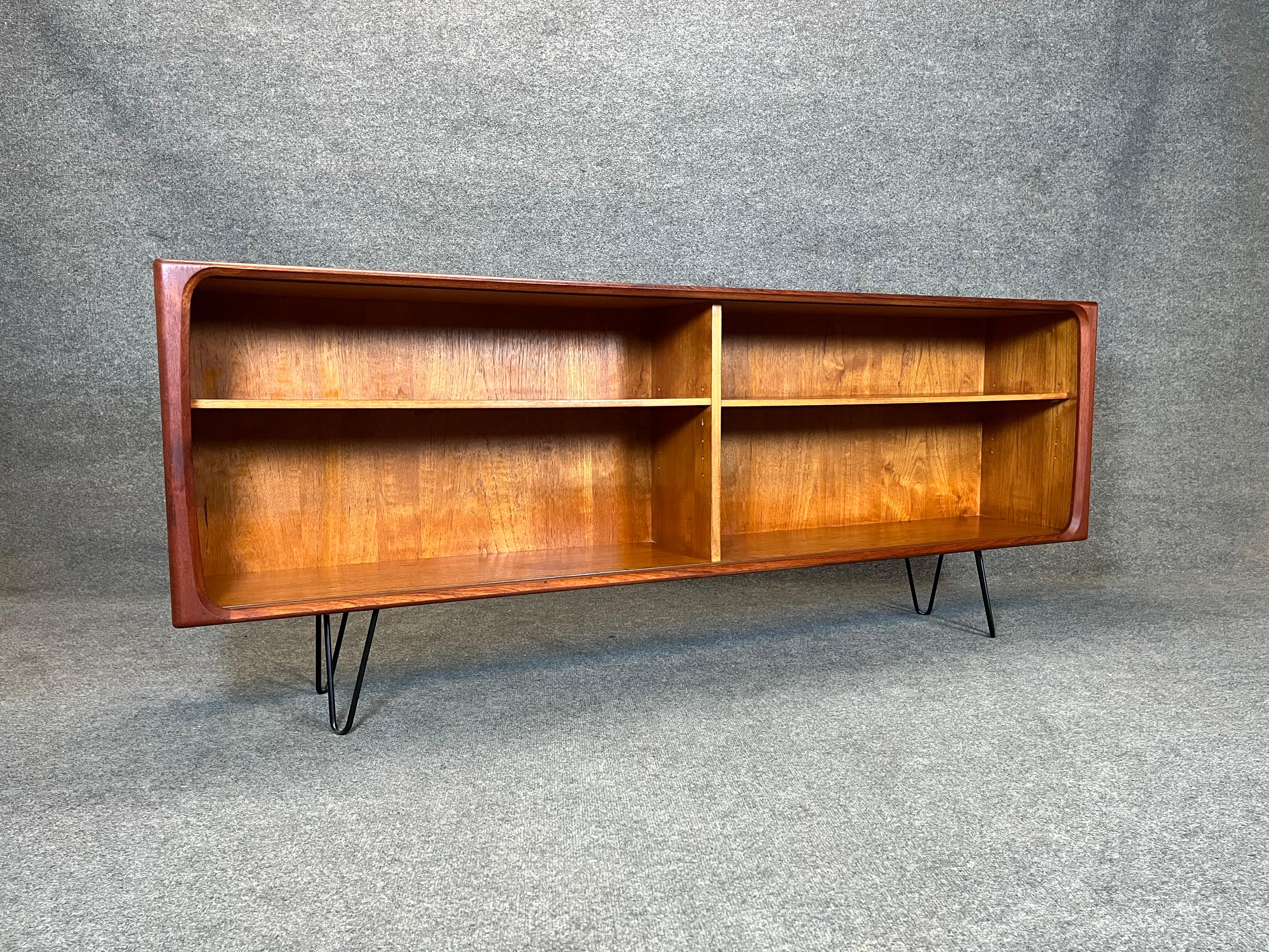 Vintage Danish Modern Teak credenza. This piece is very versatile, could be used as a media console, bookcase or an entryway piece. 

Has 2 adjustable shelves on each side. Finished teak back.

Piece is in good vintage condition with age appropriate