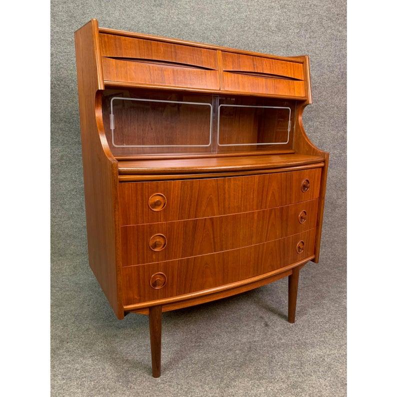 Here is an exquisite 1960s secretary desk in teak wood attributed to famed designer Arne Vodder recently imported from Denmark to California.
On its lower side, this case good features beautiful detail in the split circle handles of all three
