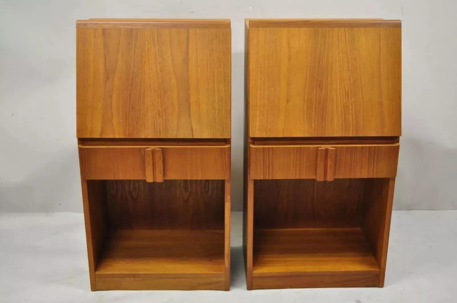 Vintage Mid Century Danish Modern Teak Tall Bedside Cabinet Nightstands - Pair. Item features drop front cabinets, beautiful wood grain, original stamp, 1 drawer, clean modernist lines. Circa Mid 20th Century. Measurements: 32.5