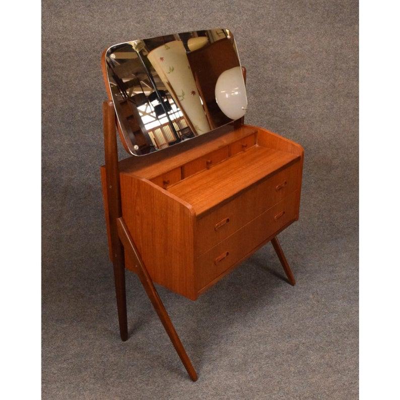 Here is a beautiful 1960s vanity in teak wood in the style of Arne Vodder recently imported from Denmark to California.
This special piece features an adjustable mirror (there is a small chip the size of a penny on the lower right side), an
