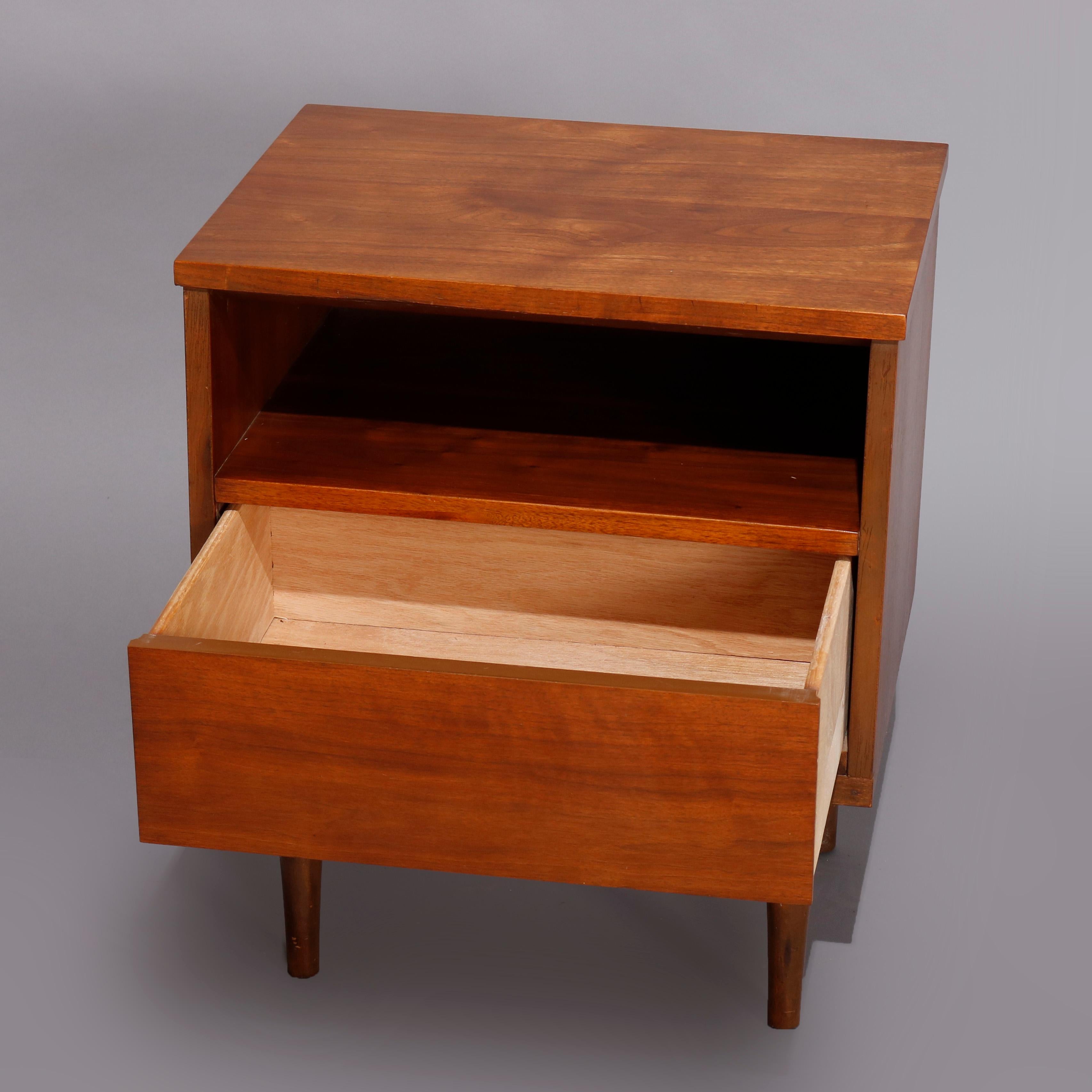 A vintage midcentury Danish modern end or nightstand offers walnut construction with upper shelf over drawer, raised on turned and tapered legs, circa 1960

Measures: 24.25