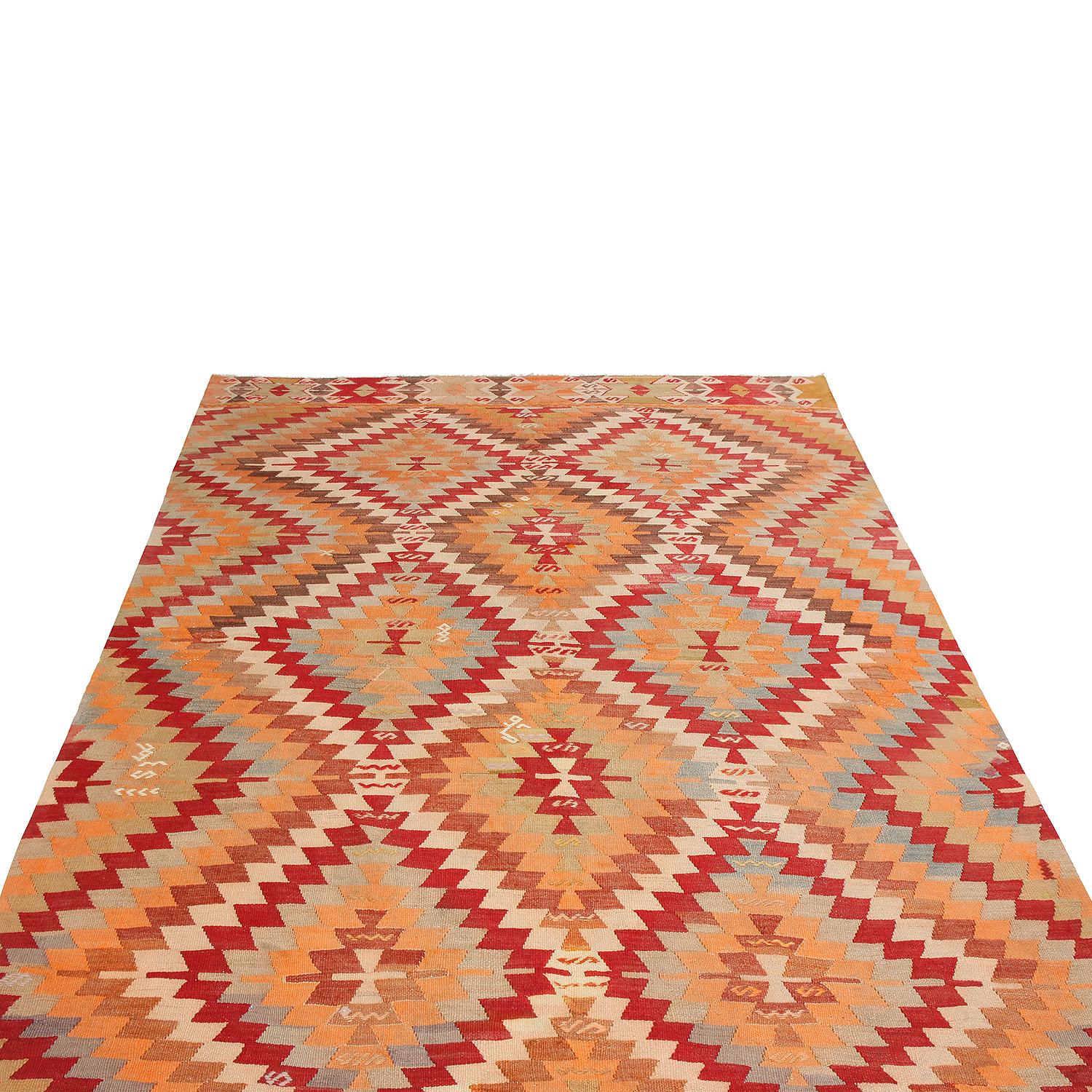 Flat woven in high-quality wool originating from Turkey between 1940-1950, this vintage hand-woven Kilim rug enjoys an atypical emphasis on golden-yellow colorways particular to a select number of designs from this era, further complemented by rich