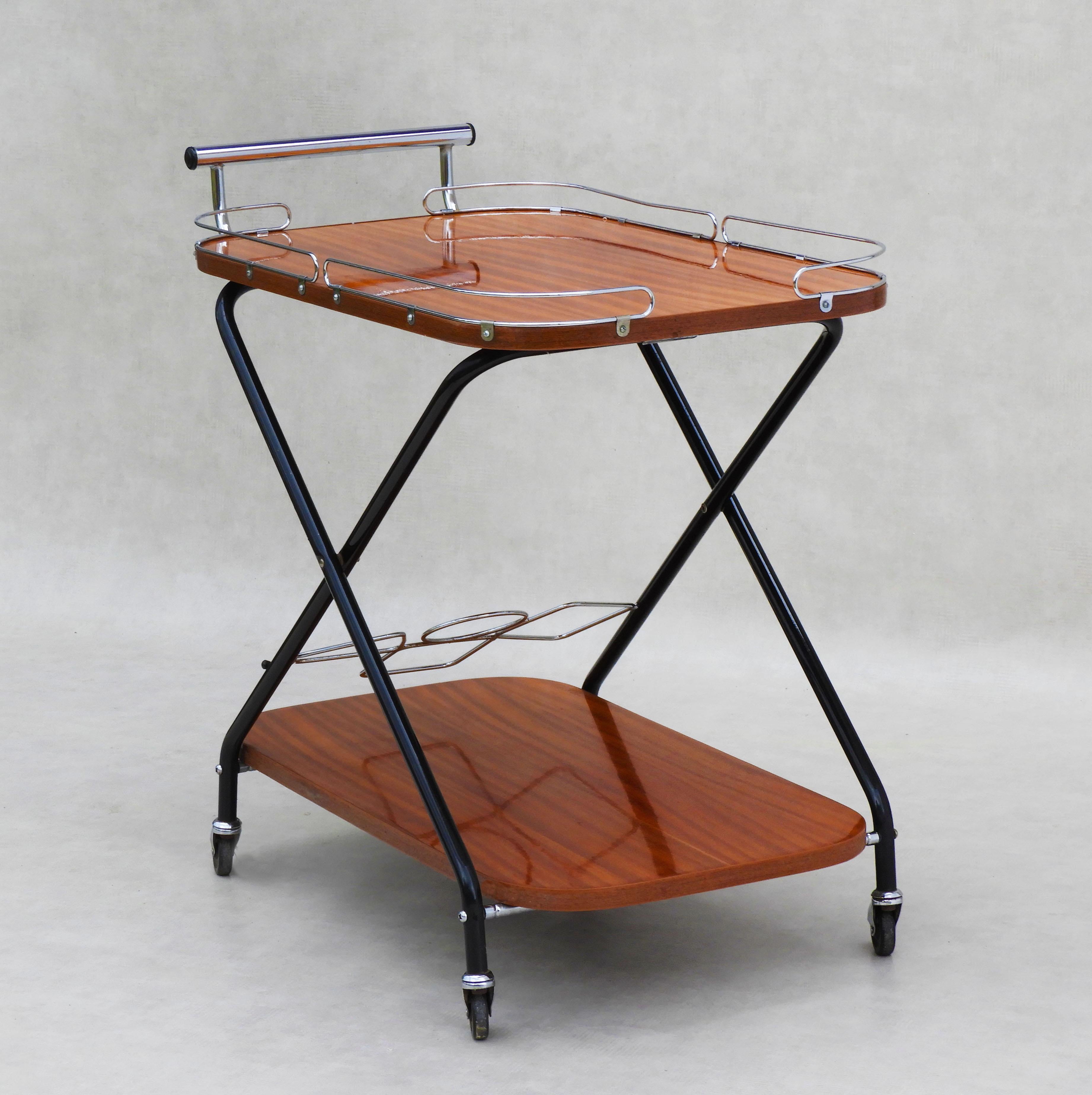 Vintage Mid Century drinks trolley bar cart 1960sFrance

Stylish Mid Century Modern French Hostess Trolley.

Two tiered folding drinks trolley, bar cart, serving table.

High gloss teak surface, chrome detailing.

Practical, solid and