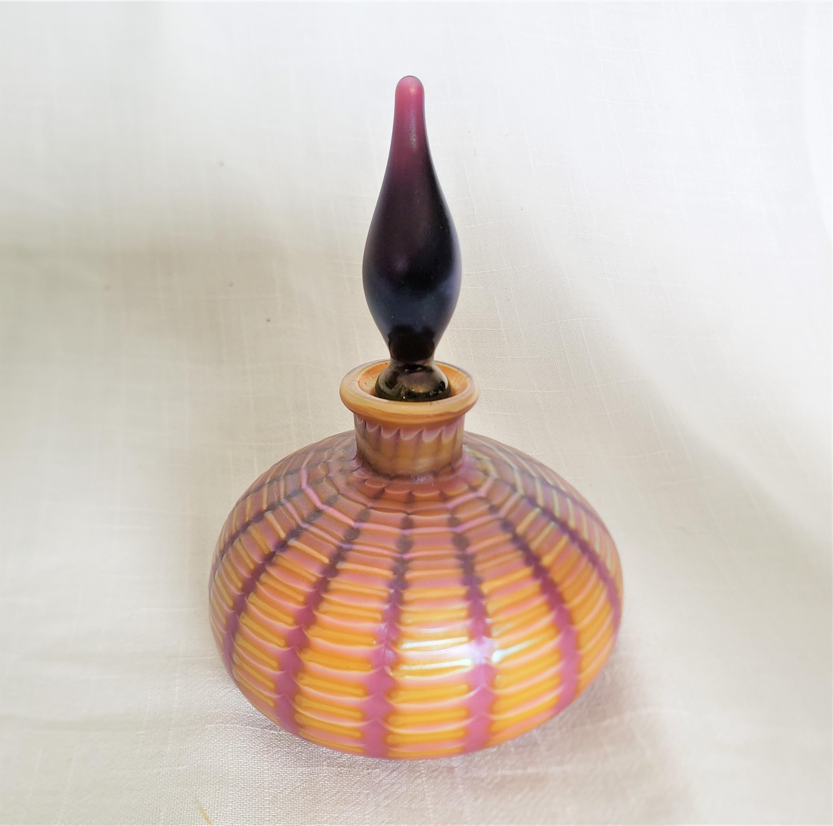 This art glass perfume or scent bottle bears no maker's signature, but is presumed to have originated from the Czech Republic and dates to approximately 1970 and done in an Art Deco style. The bottle is done in a vibrant tangerine orange glass with