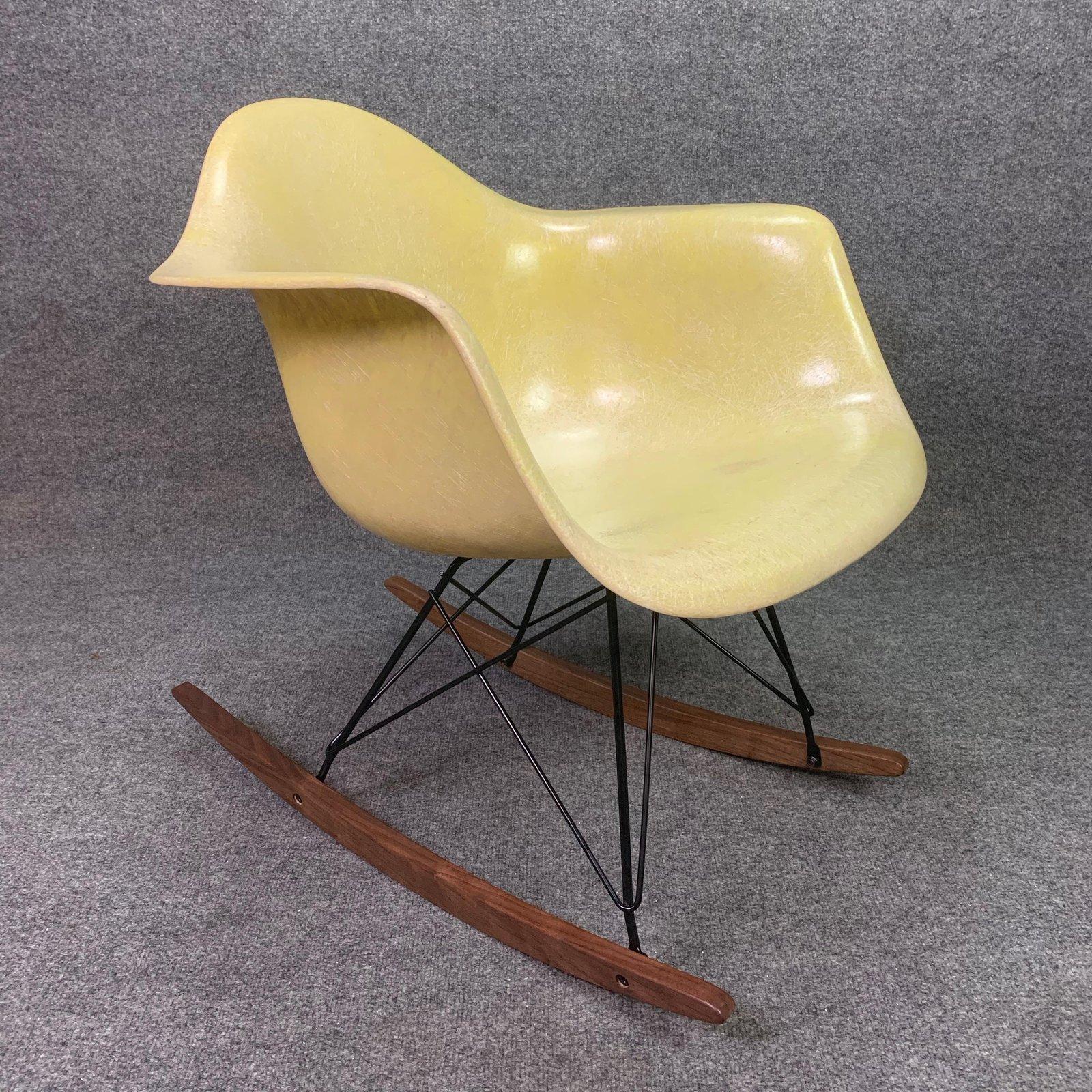 Here is a classic American made fiberglass rocking chair designed by Charles Eames. 
This early 1950's shell, with its pale yellow color and vibrant fiber details, has been cleaned up and received a new gel coat finish. All the the shock mounts are