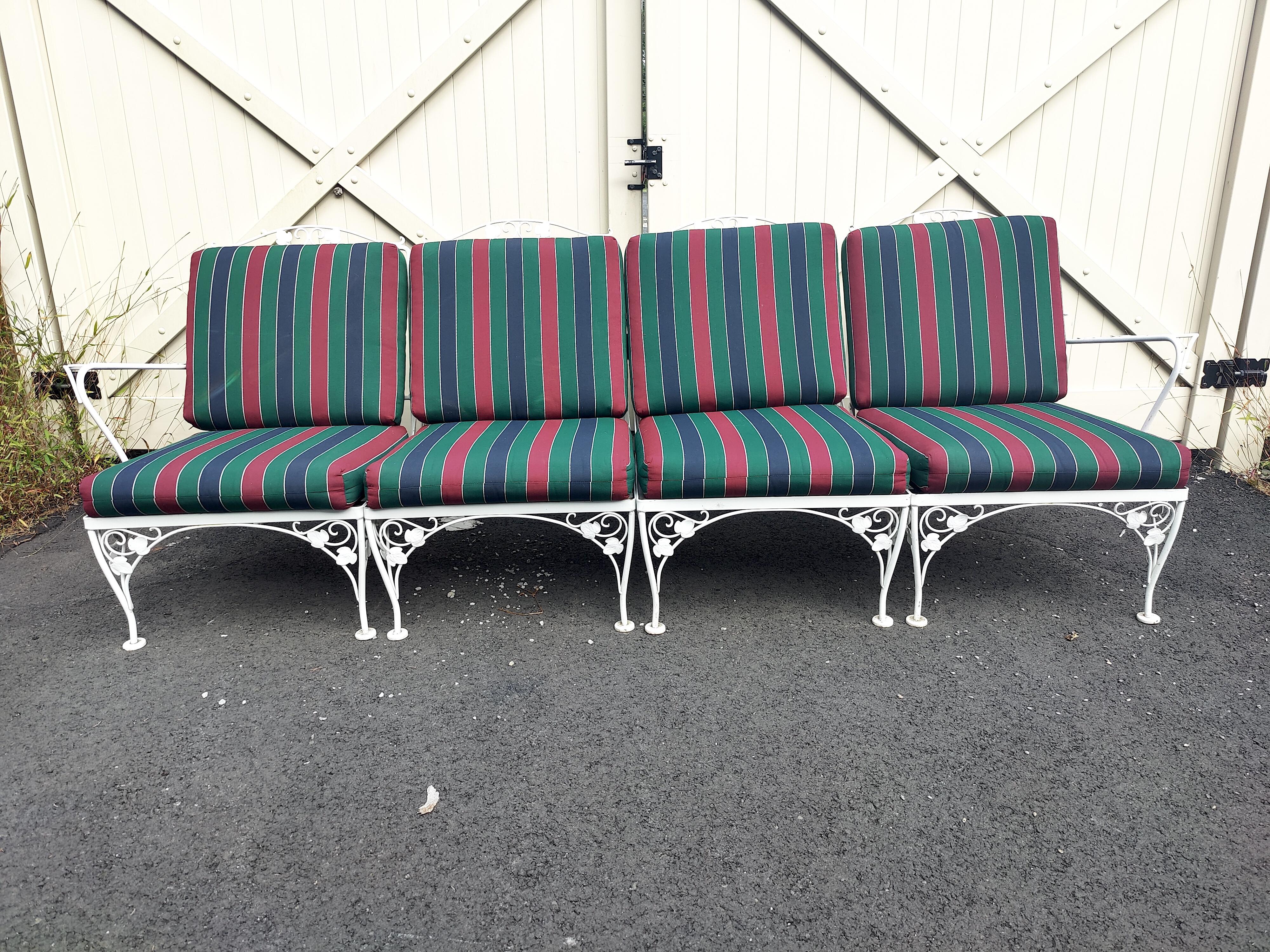 Mid-Century outdoor lounge bench. Made out of sturdy wrought iron. This bench features elegant scrollwork and floral designs Perfect for any patio, pool, balcony setting. These (4) chairs can be arranged as a bench or used individually. Cushions
