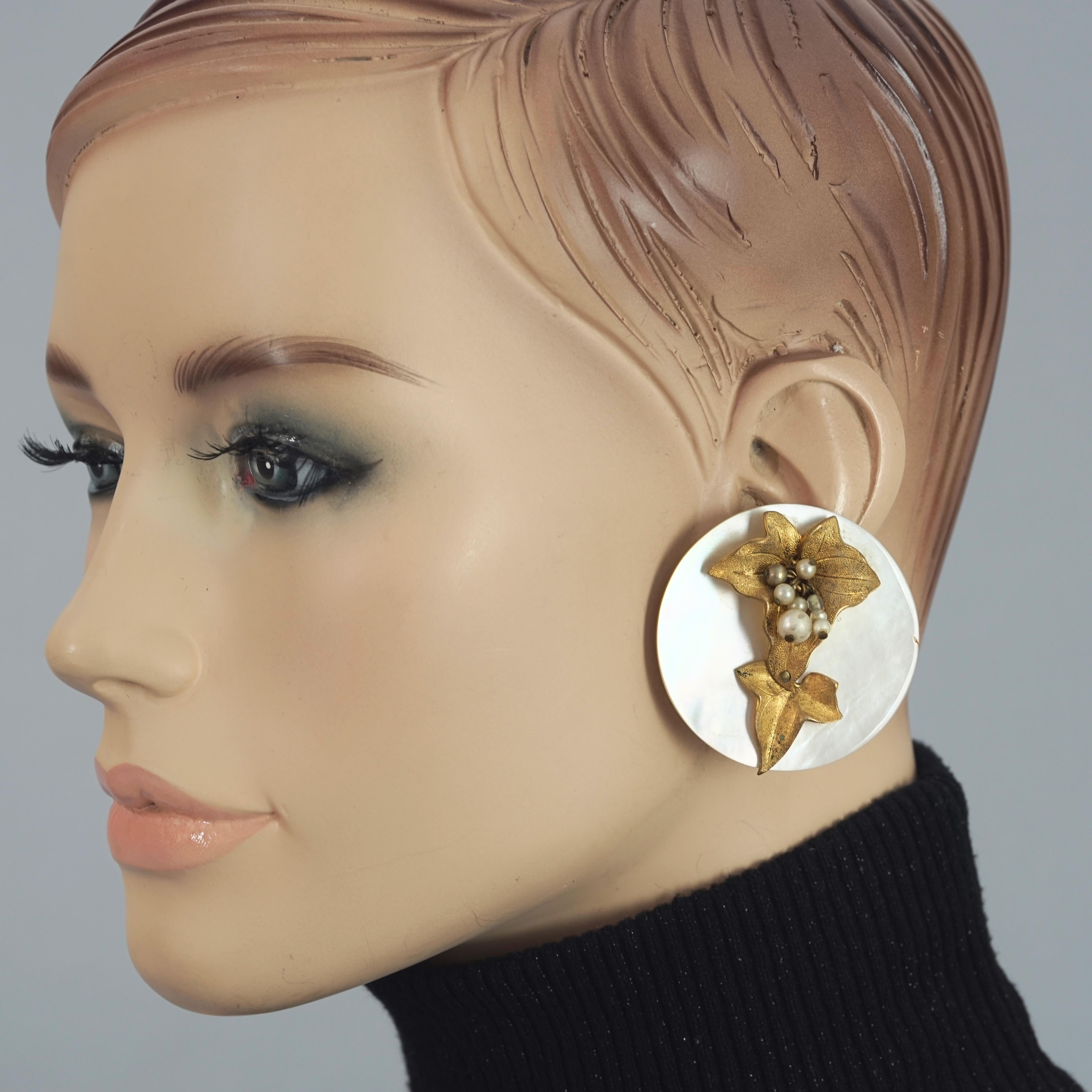 Vintage Mid Century French Mother of Pearl Jeweled Disc Earrings

Measurements:
Height: 1.85 inches (4.7 cms)
Width: 1.85 inches (4.7 cms)
Weight per Earring: 17 grams

Features:
- Massive mother of pearl disc earrings.
- Textured leaf metal overlay