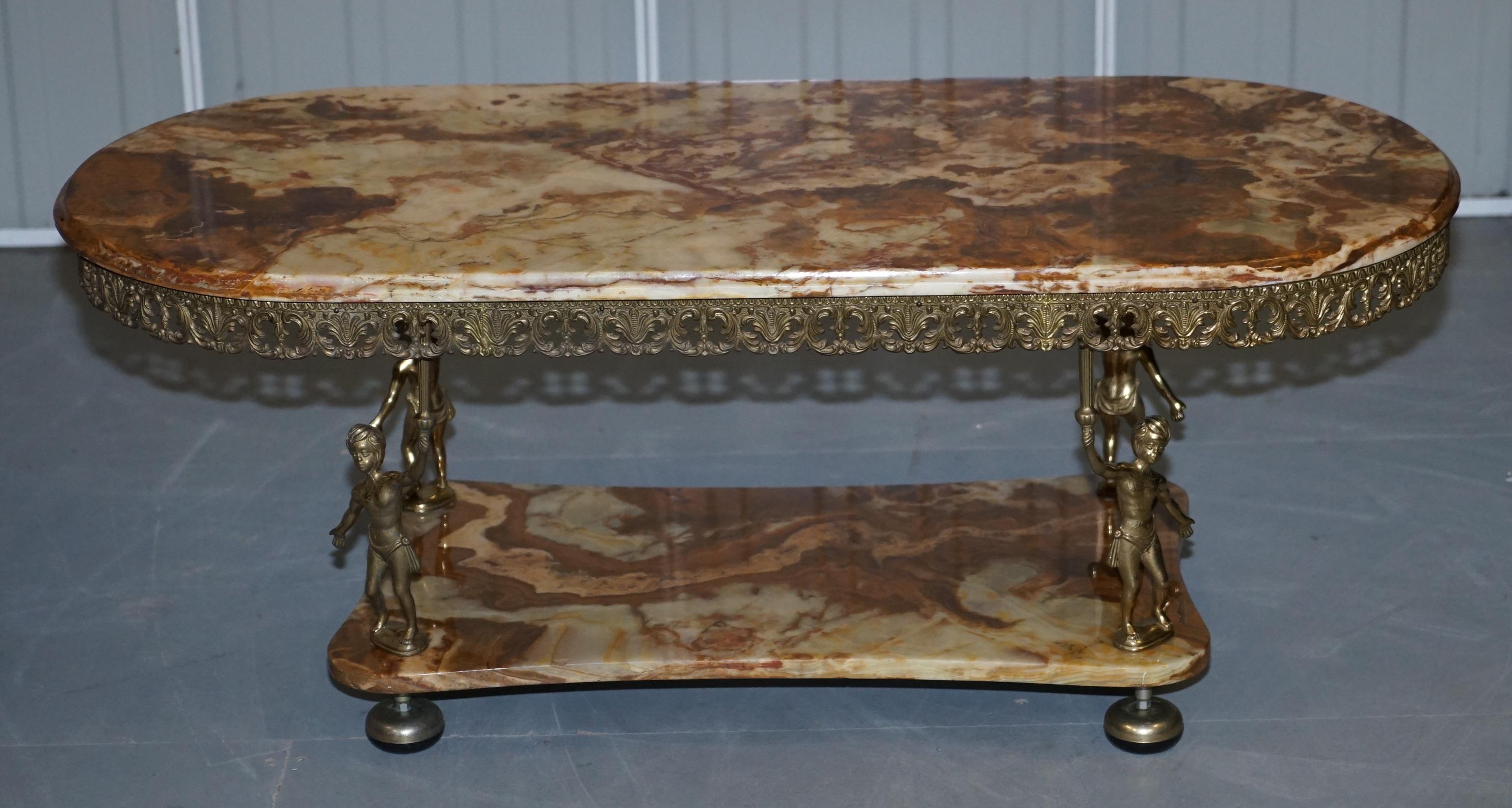 We are delighted to offer for sale this very decorative marble and gilt brass framed coffee or cocktail table

A very good looking and well made piece with a lot of high quality detailing. It was sold tome as Marble but it could be Onyx 

We