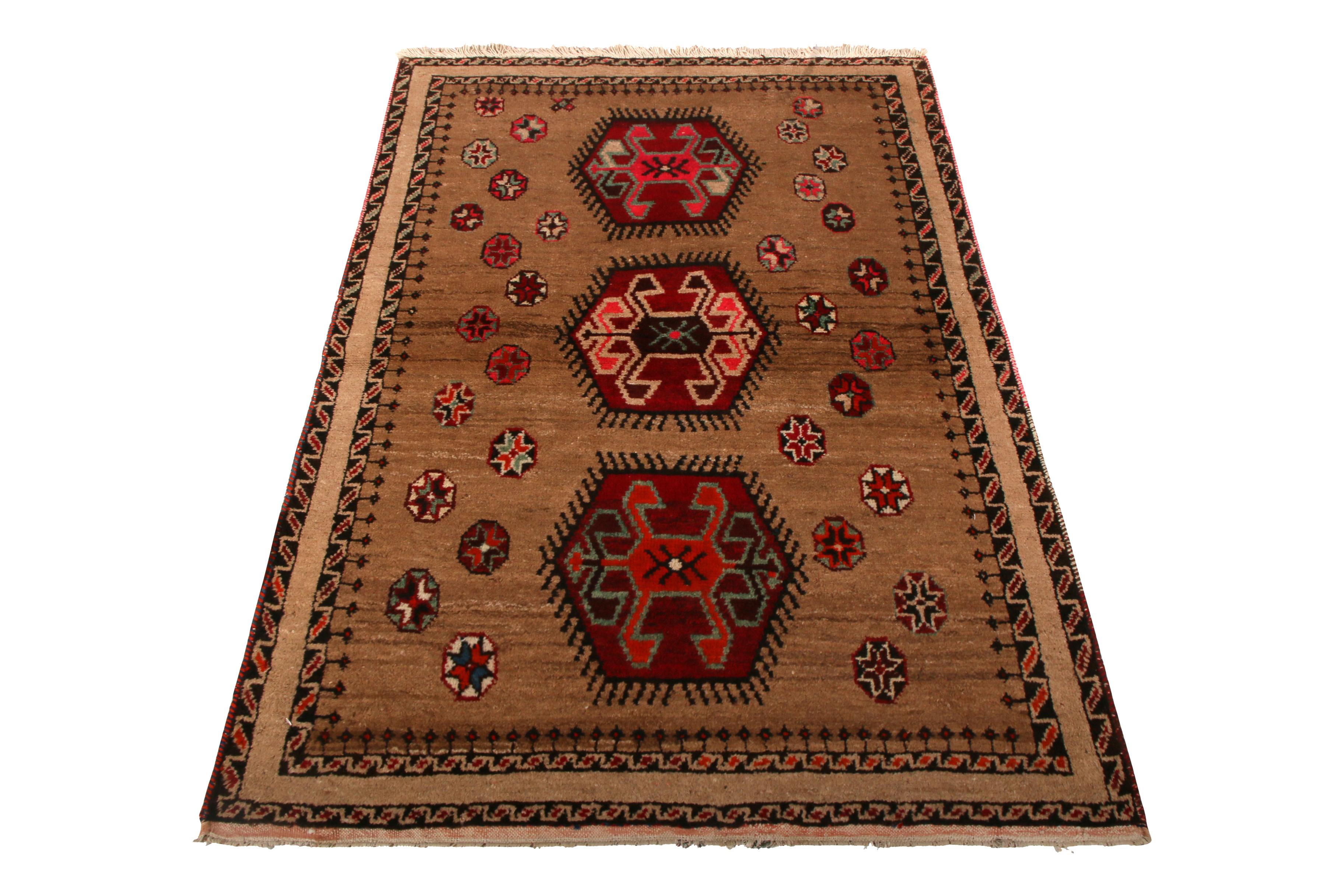 Made in hand knotted wool originating between 1950-1960, this vintage midcentury Gabbeh Persian rug enjoys a rich transitional take on Classic tribal elements in a versatile size. The juxtaposition of the symmetry and whimsy in the medallions