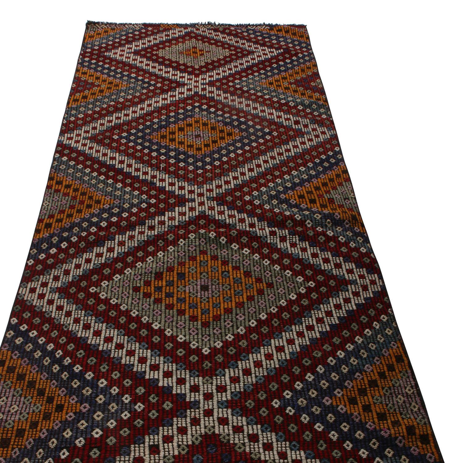 Handwoven in Turkey originating between 1950-1960, this vintage wool kilim runner enjoys a distinguished, textural high-low approach to flat weaving, beautifully complementing the classically radiant red, orange, blue and white hues adoring the