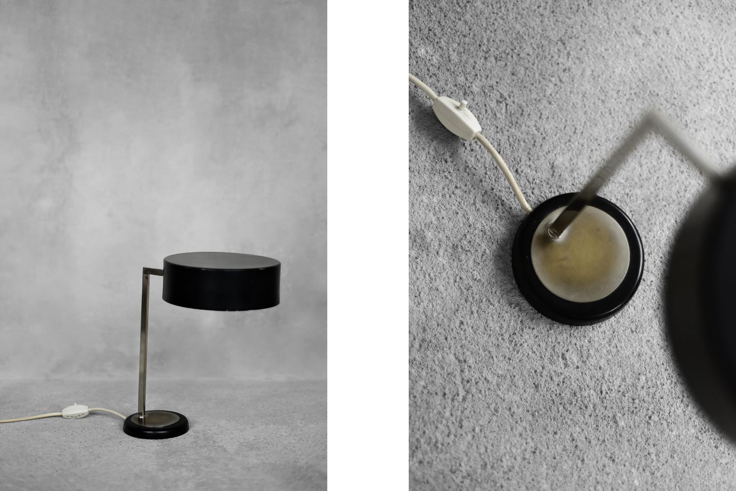 This minimalist lamp was produced in Germany during the 1960s. The lamp captivates with its simple design. The black metal lampshade and round base are connected by a solid, sharp arm. The lamp has strong light concentrated in one point, which