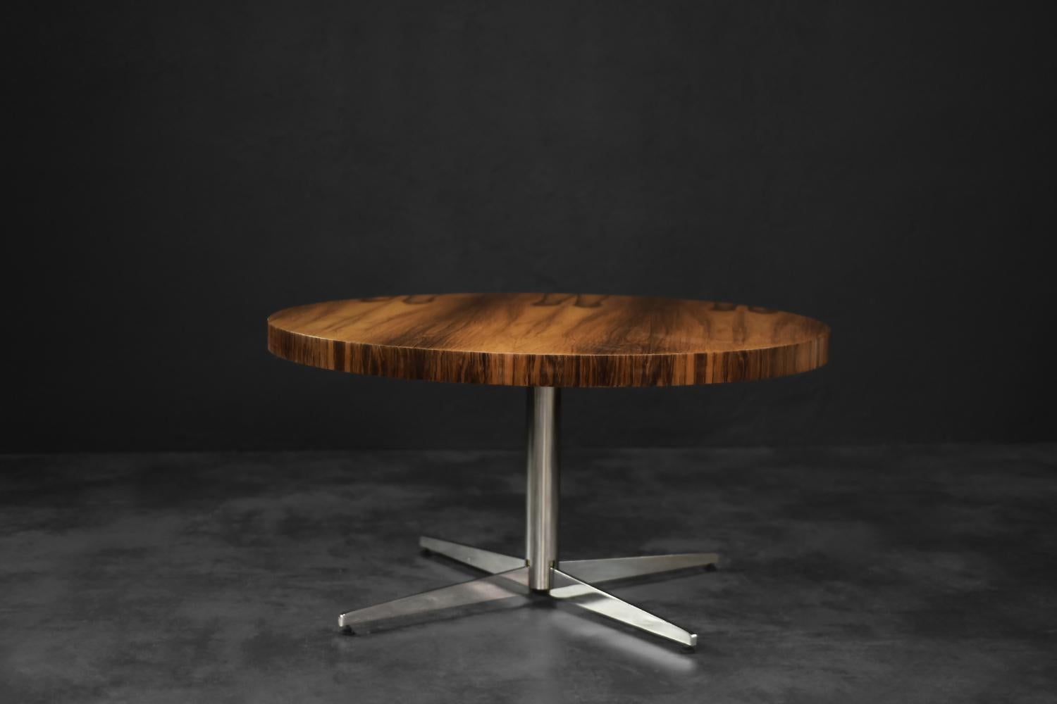 This rare, modernist coffee table was produced by the German manufacturer Ilse Möbel during the 1970s. The large, round top is finished with rosewood in a chestnut shade of brown. It is characterized by rich and interesting grain. The base is a