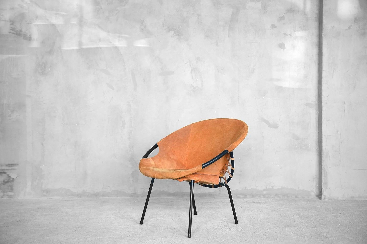 This circle chair or balloon chair was designed by Lusch Erzeugnis for Lusch & Co, in Germany during the 1960s. It features a black metal frame and suede leather seat. This chair is in original vintage condition and has traces of age: scratches on