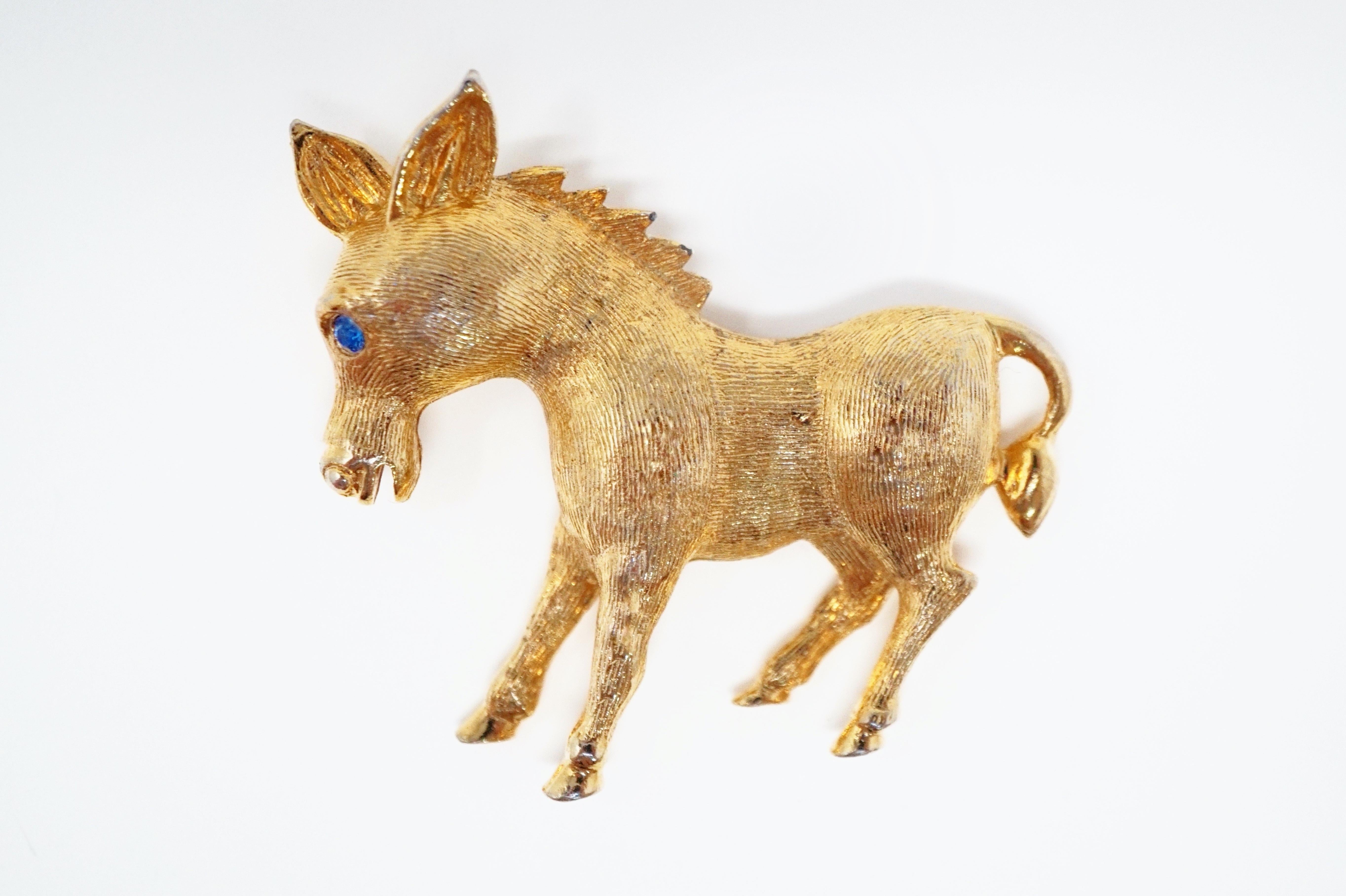 This adorable vintage gold-plated pony brooch from the mid-century era, features a brushed texture and a sweet blue rhinestone eye. Perfect for equestrians or animal lovers in general and a wonderful addition to your vintage jewelry
