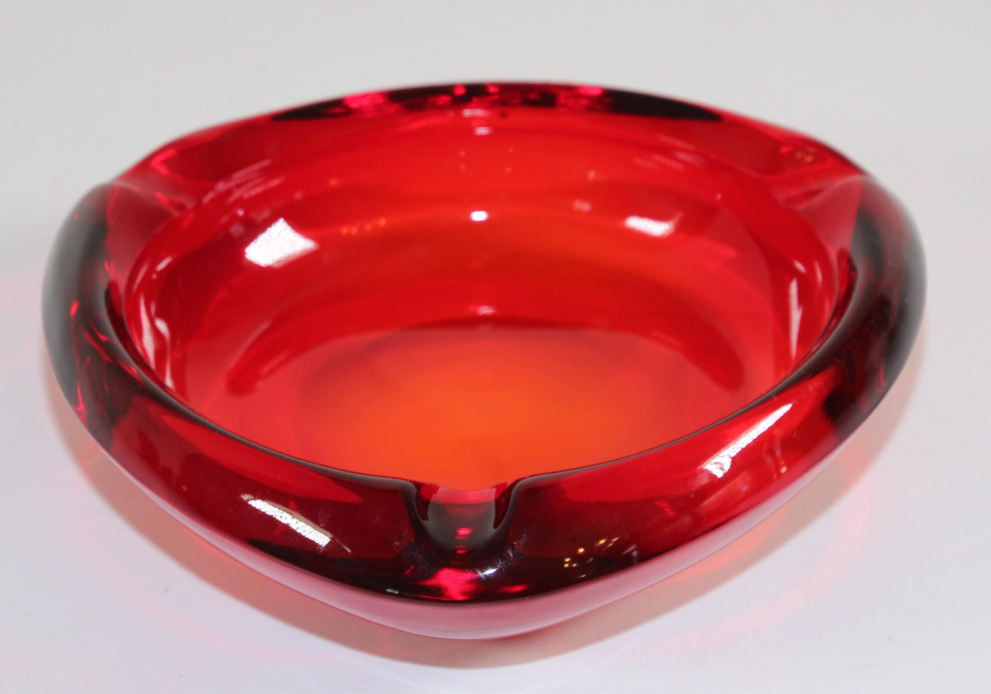 Vintage modernist mid-century glass ashtray ruby red triangular.
Mid-century glass ashtray circa 1960's - 1970's USA. 
Large and stunningly beautiful art glass ashtray by Viking in their beautiful ruby red color. 
Back when people still smoked