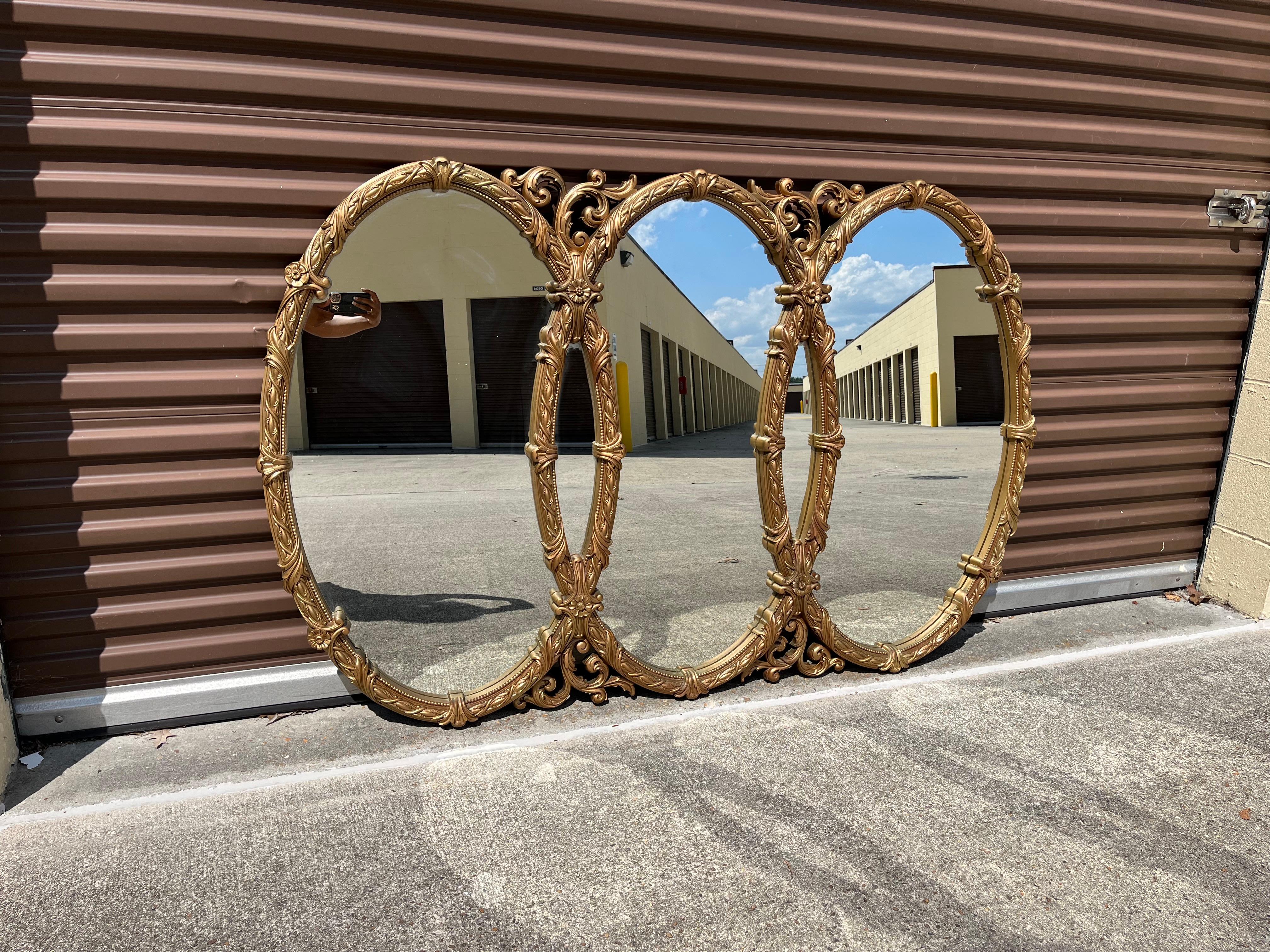 Introducing our exquisite Mid-Century Triple Oval Interlocking Gold Ornate Wall Mirror - a truly captivating piece that will transform your living spaces into a realm of timeless elegance. Crafted with meticulous attention to detail, this mirror