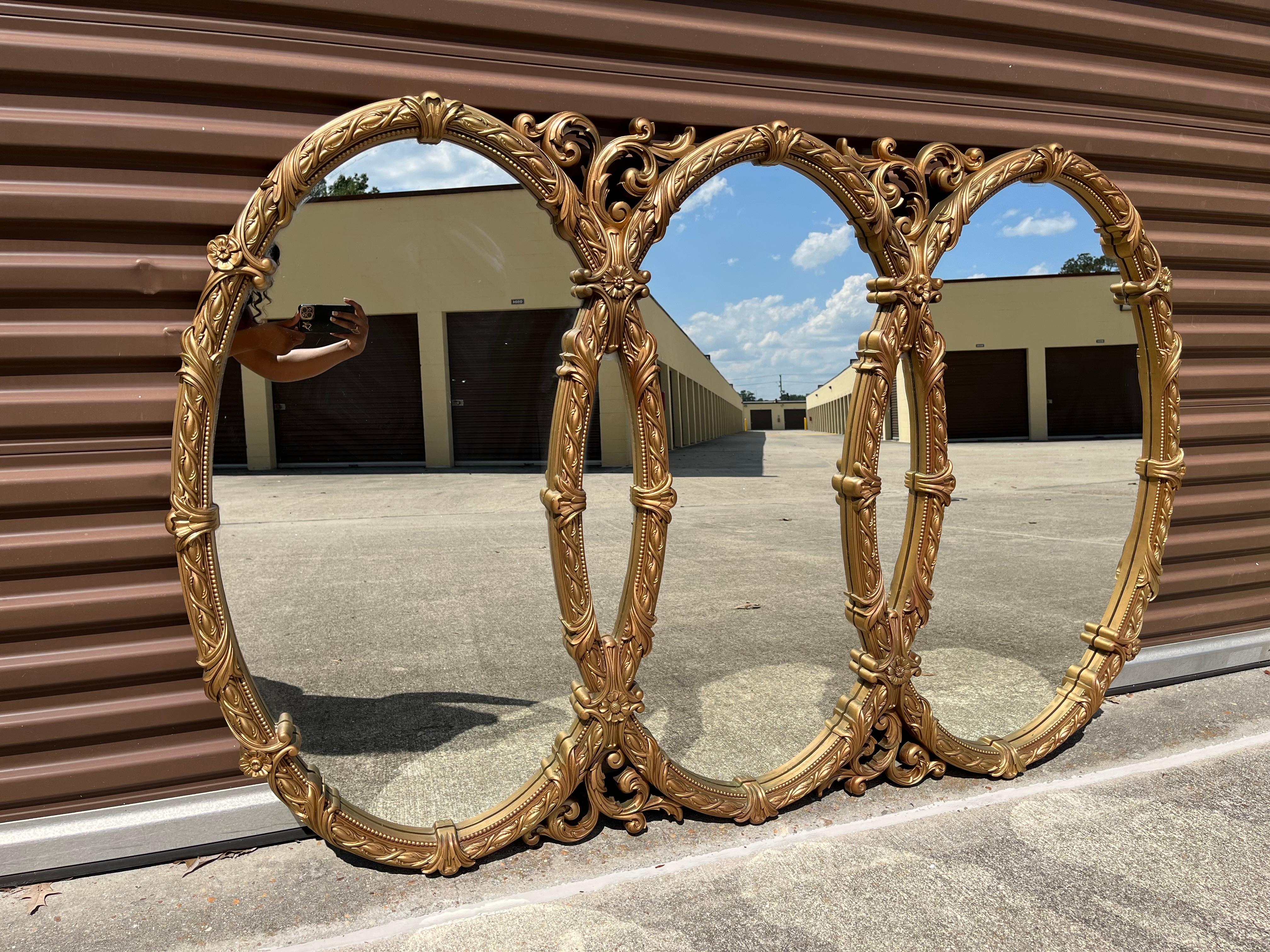 Te presentamos nuestro exquisito Espejo de Pared Ornamentado en Oro de Mediados de Siglo, con tres óvalos entrelazados: una pieza realmente cautivadora que transformará tus espacios vitales en un reino de elegancia atemporal. Elaborado con