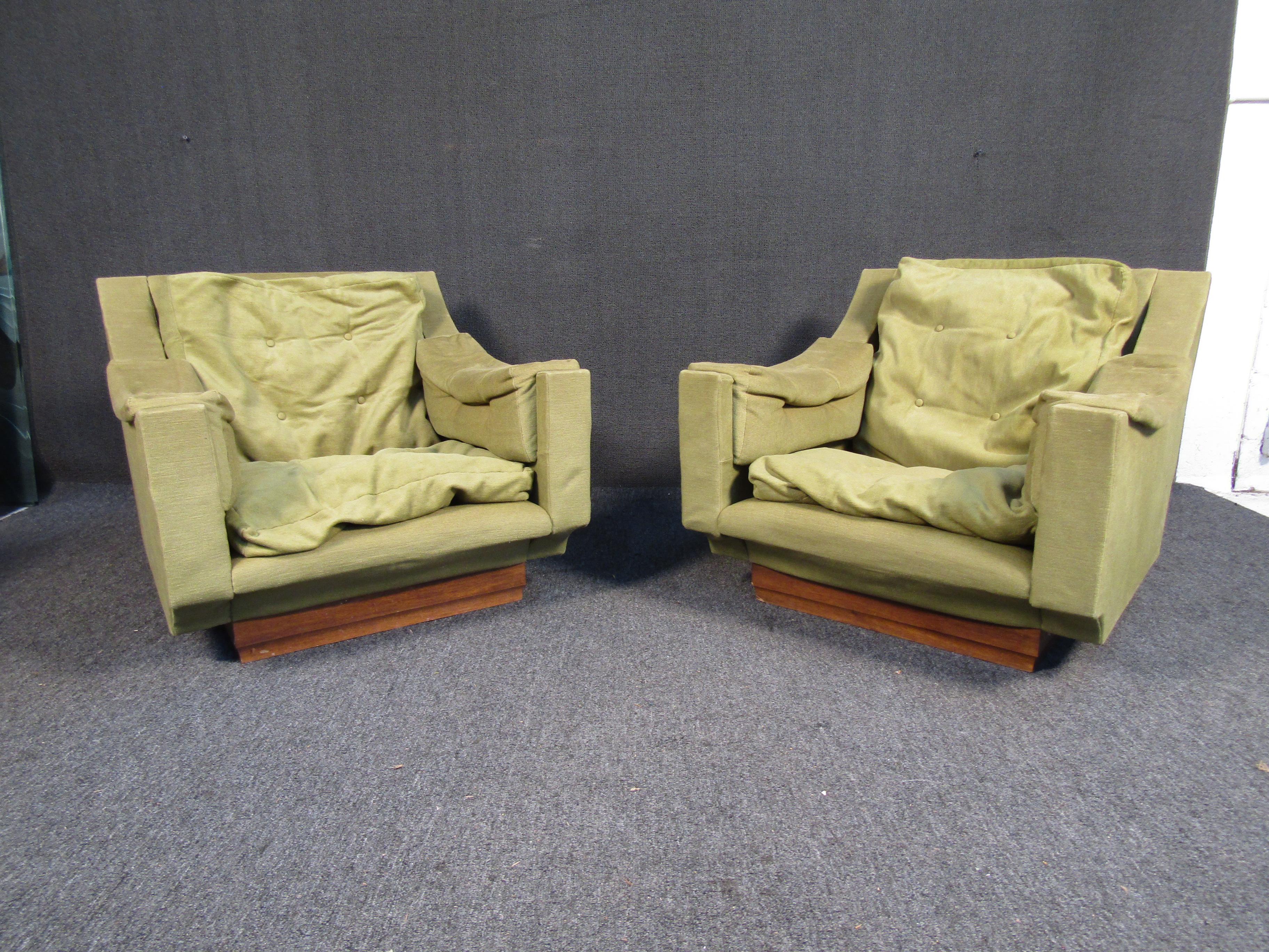 These vintage mid-century green lounge chairs feature sloped armrests, plush green upholstery and a wooden accented base. If you are looking for chairs to add vintage flare to your living space these would be a perfect addition. 

Please confirm