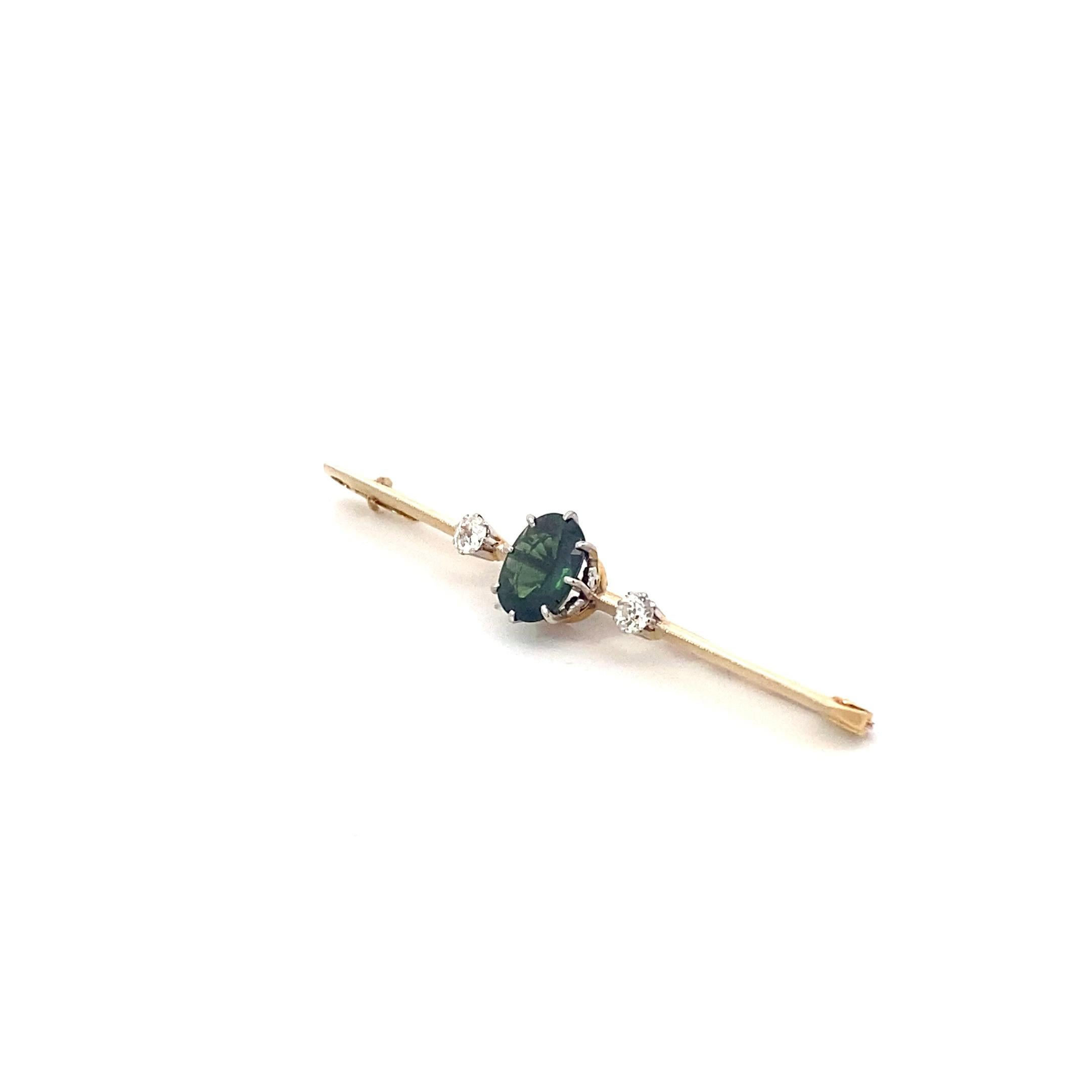 Featuring a whopping 2.3 carat green sapphire and two mine cut diamonds weighing 0.4 cts, this luxe 18k yellow gold brooch is emblematic of the clean lines and rich colors of mid-century fine jewelry. 

Over two inches long, this pin is sure to