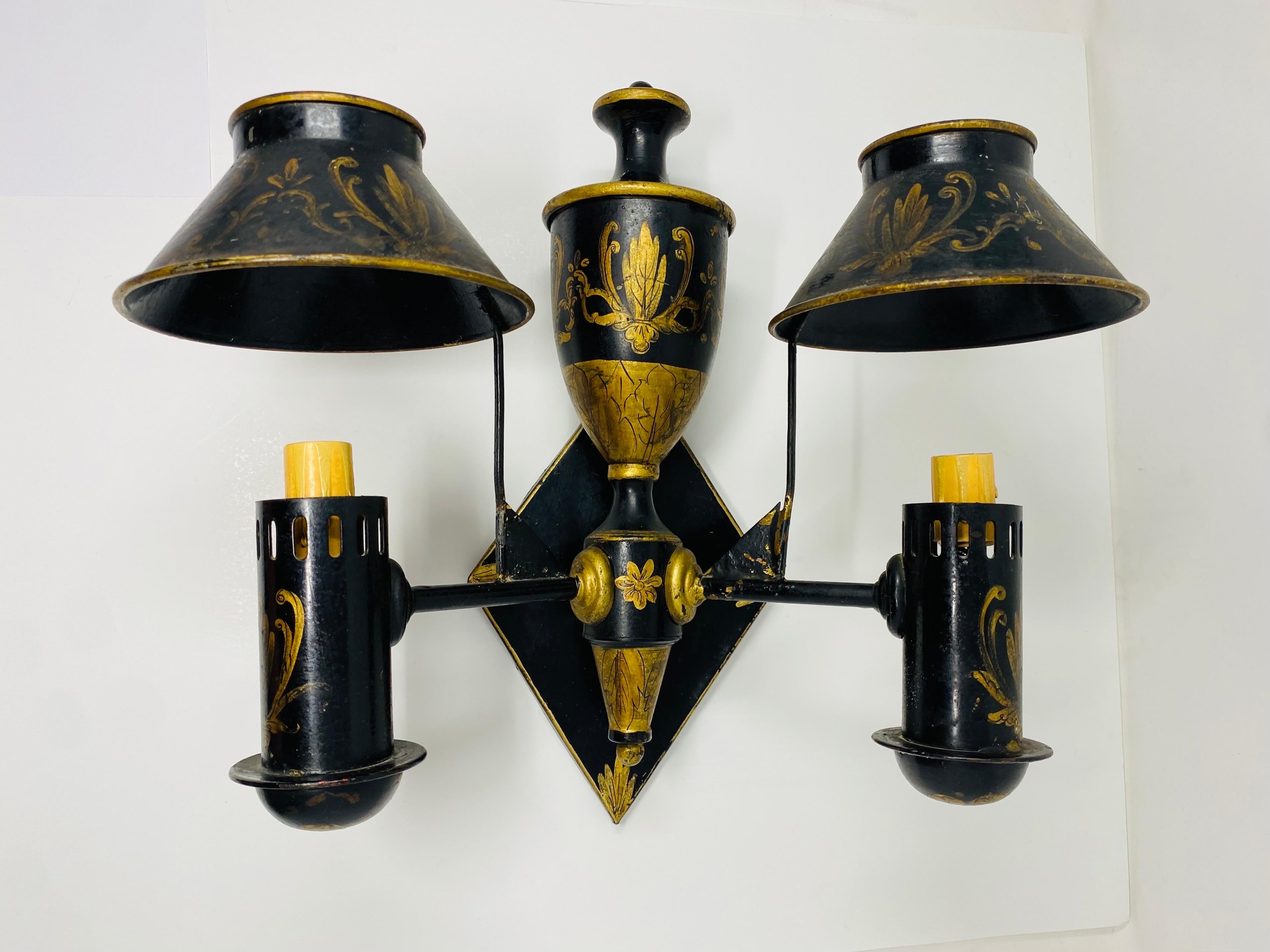 Beautiful pair of French sconces in Tole.  These fabulous pieces date to the 1950s and are unique and rare.  Delicate scroll work and artistry are present in these pieces.  Elegant and timeless, these pieces add glamour and establish a style of