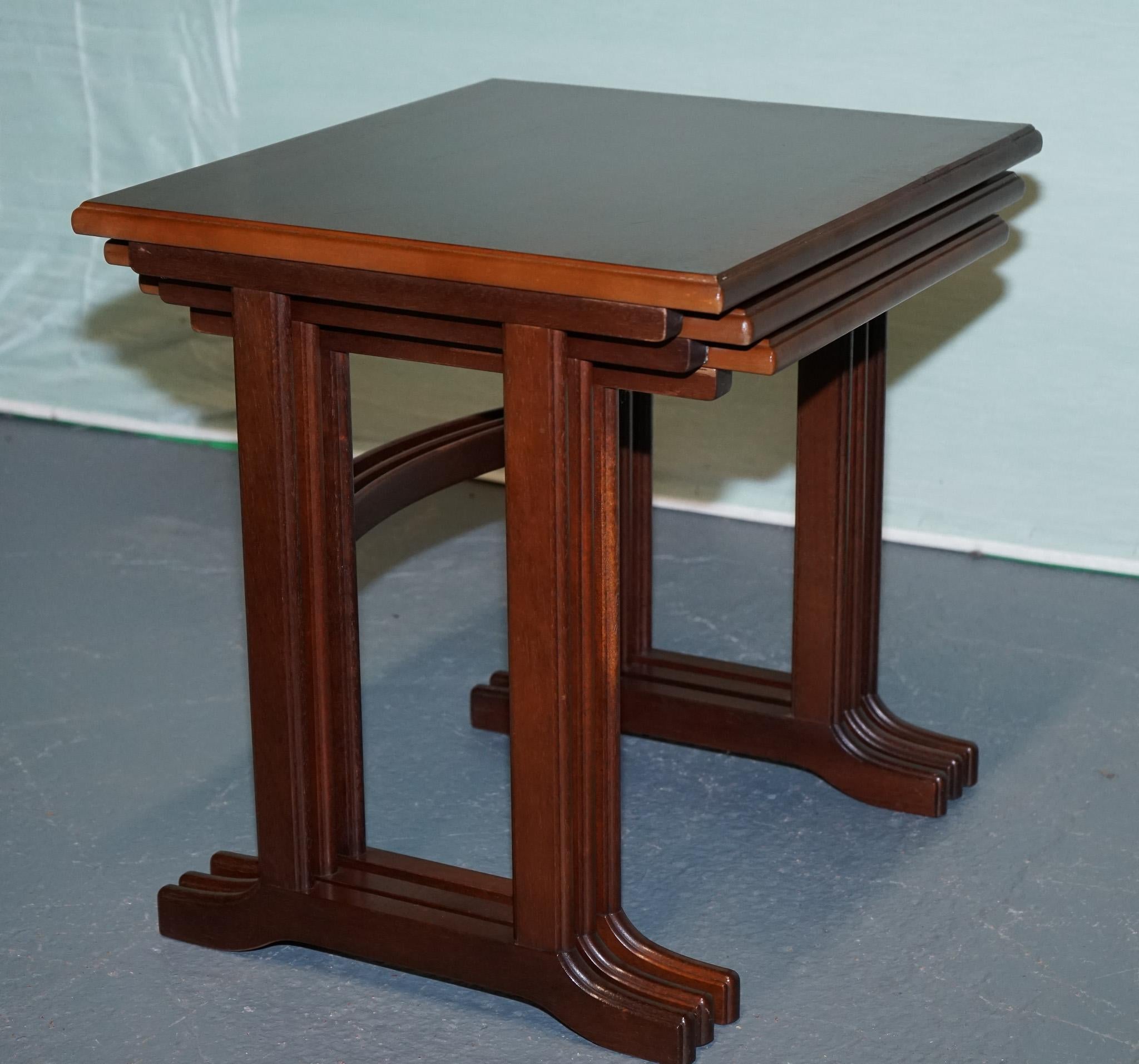 
Antiquités de Londres



Cet ensemble de trois tables en bois dur du milieu du 20e siècle présente d'élégants plateaux rectangulaires et de minces pieds tripodes qui s'emboîtent pour un rangement compact. Les tons chauds et riches du bois et le