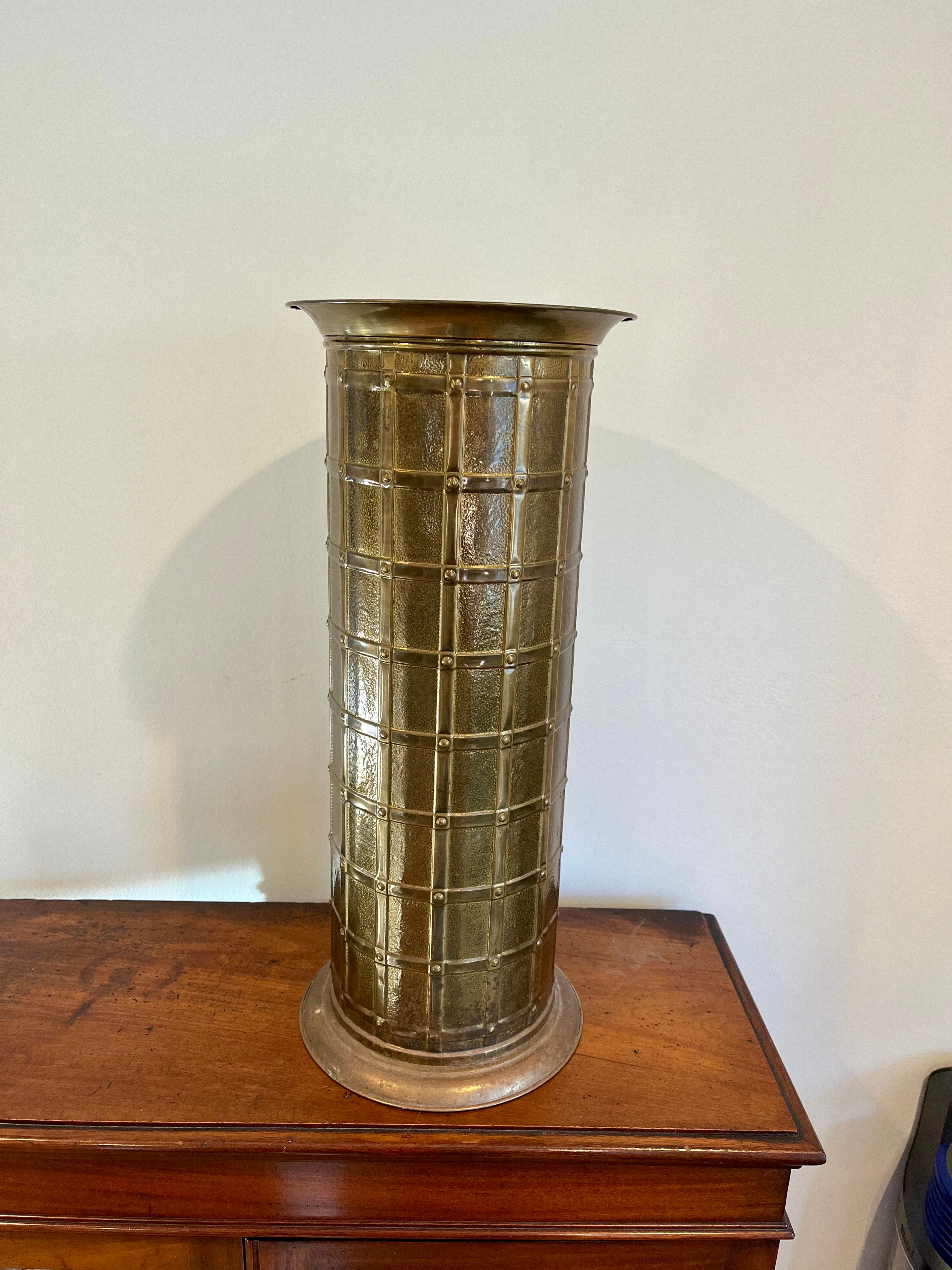 Elevate your entryway or living space with this striking Mid-Century Hollywood Regency brass umbrella or stick stand, featuring a bold lattice grid motif. Crafted from polished brass, this cylindrical piece reflects the glamorous and eclectic