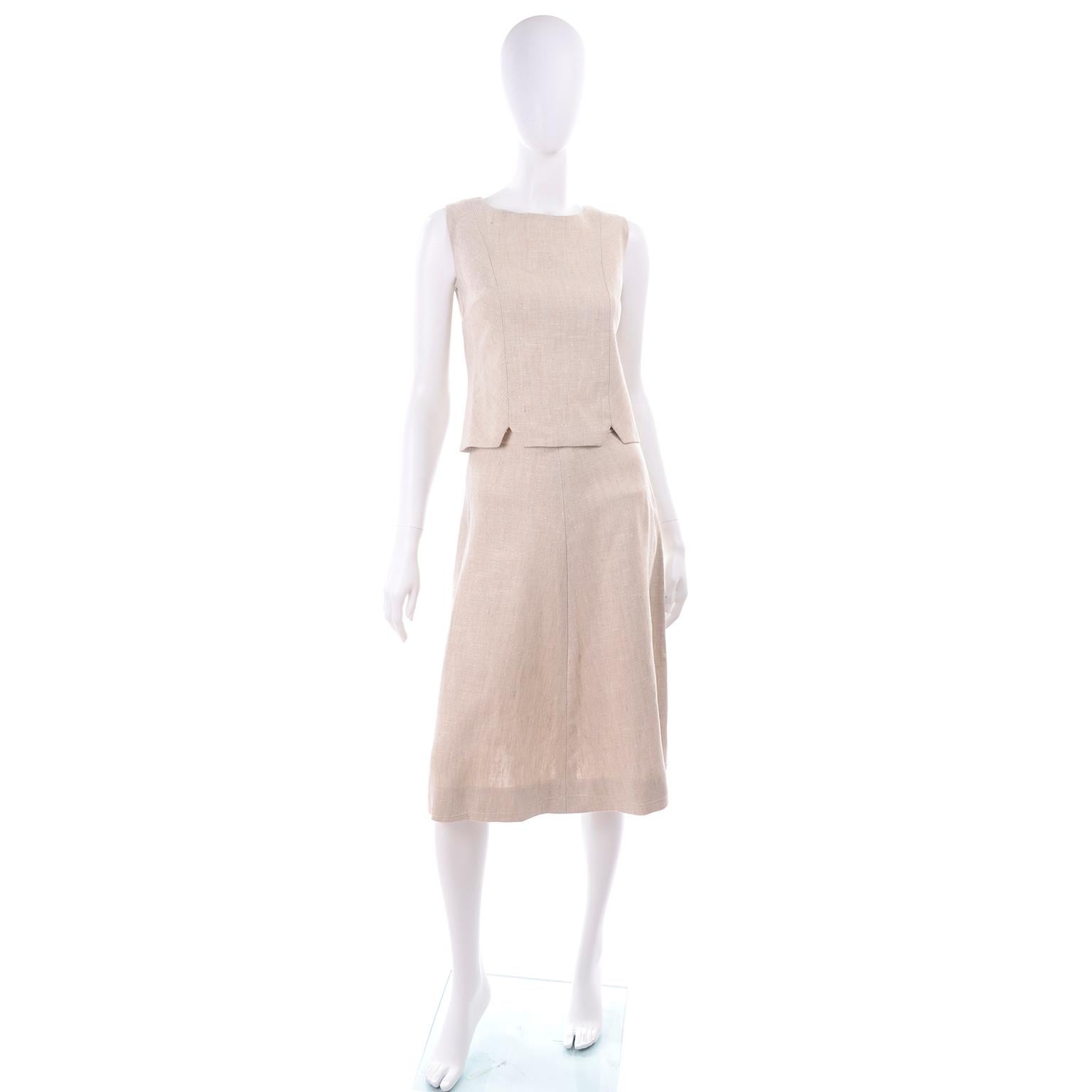 This is a 3 piece vintage mid century outfit in a luxe natural linen that includes a short sleeve jacket, a sleeveless top, and an a-line skirt.  The jacket has darts on the front and 2 functional pockets with buttons. The top is sleeveless with a