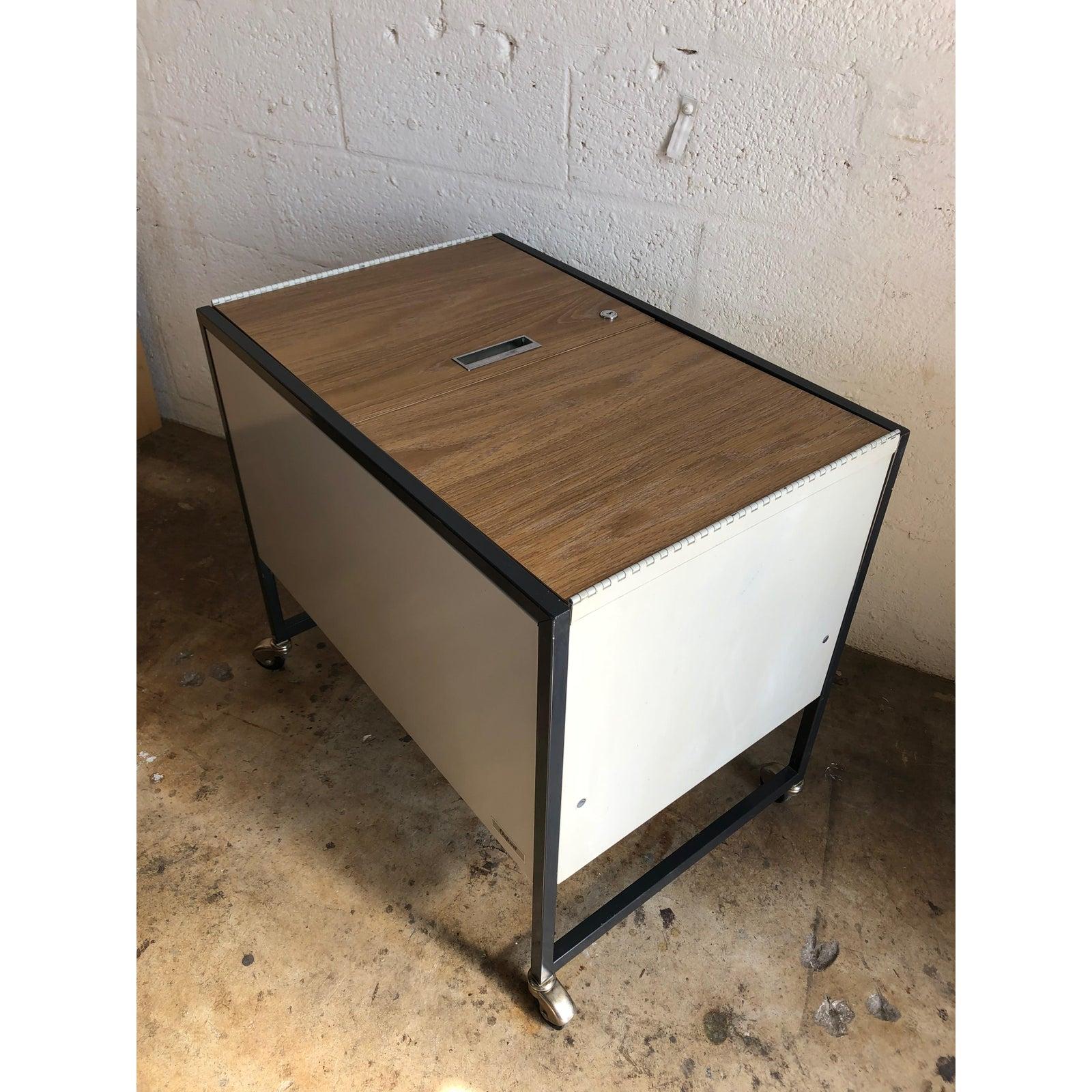 Vintage midcentury industrial filing cabinet/ cart by Oxford from the 1970s.
Unique metal cart with top laminated wood doors.
In excellent original condition with signs of wear consistent with age and history.
Some minor scratches (Please See