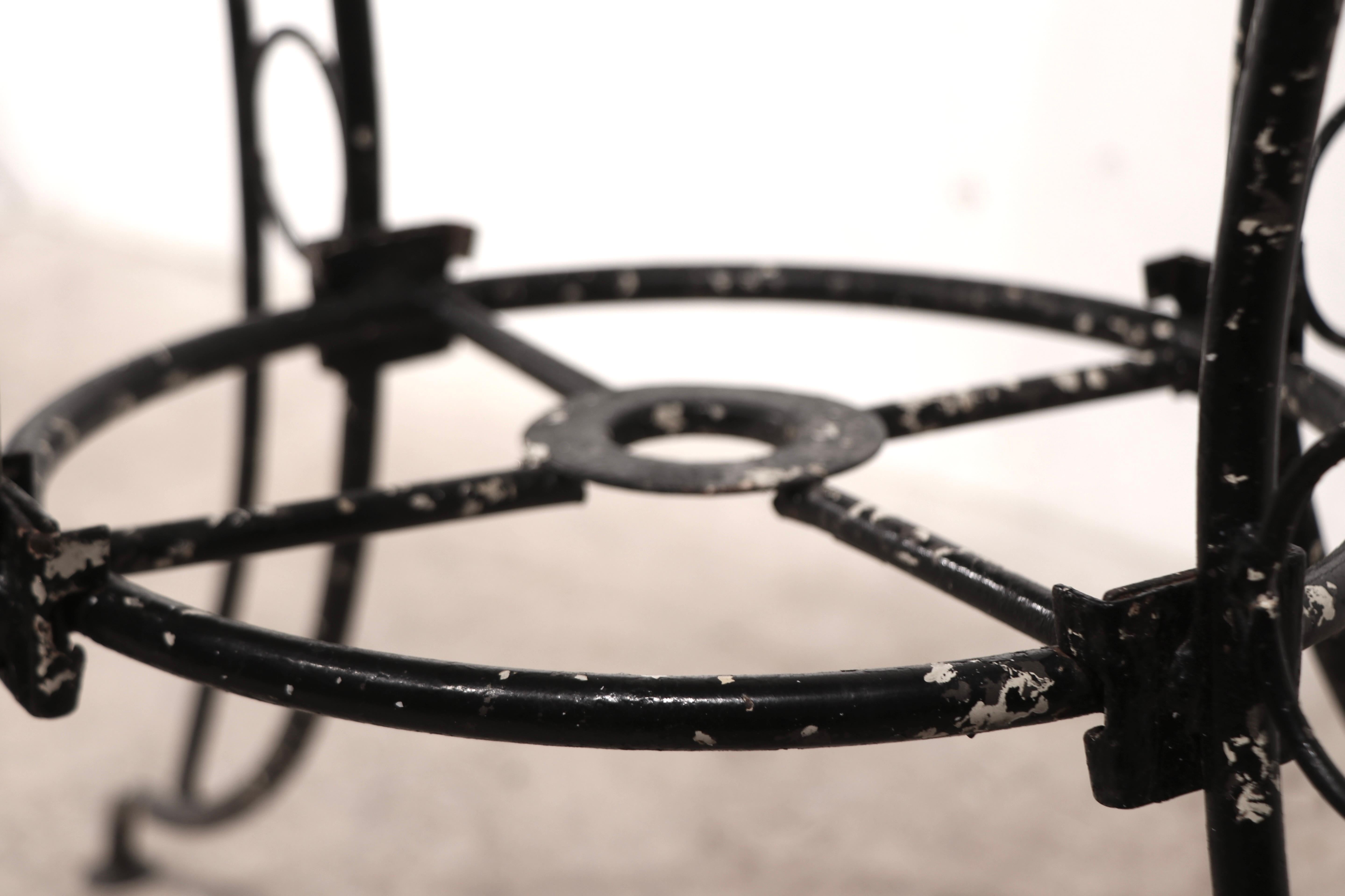 Style vintage du milieu du siècle  jardin, patio, café au bord de la piscine  table de salle à manger construite en métal tubulaire, en fonte et en maille métallique.  La table comporte un trou central conçu pour accueillir un parapluie, elle est