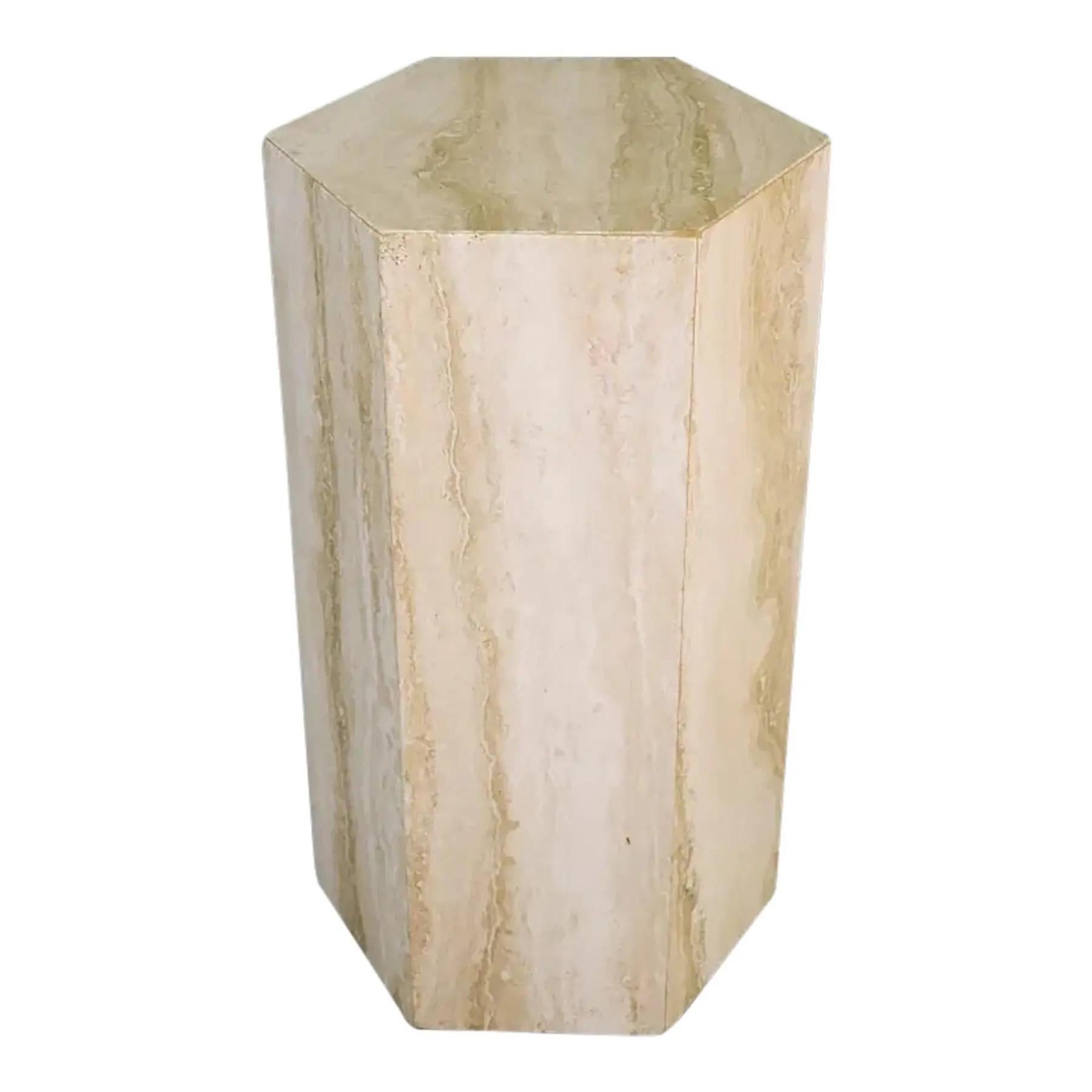 Un sorprendente piedistallo esagonale in travertino proveniente dall'Italia. Questo pezzo presenta una forma geometrica dalle linee pulite e mette in mostra la bellezza naturale della pietra di travertino, comprese le sue caratteristiche venature e