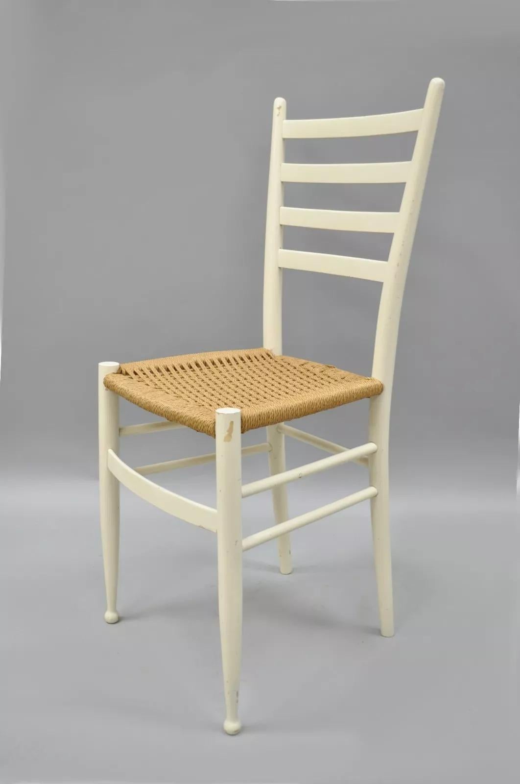 Sedia laterale vintage in stile Gio Ponti. L'articolo presenta una struttura in legno massiccio, finitura bianca, gambe affusolate, seduta in corda intrecciata, elegante forma scultorea, etichetta Made in Italy sul lato inferiore. Metà del XX