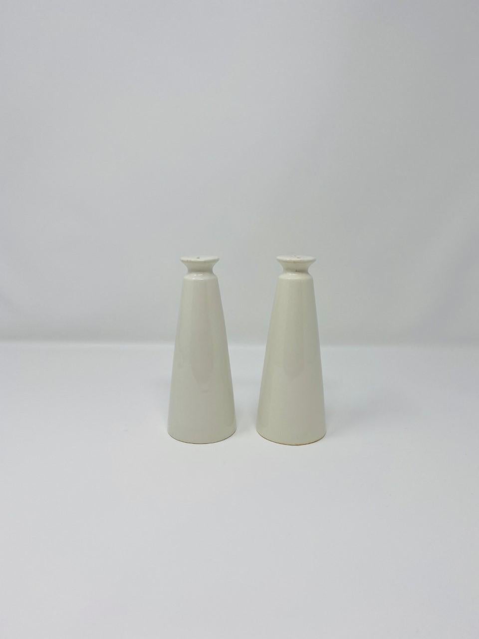 Beautiful and stylish pair of salt and pepper shakers. These vintage pieces are from Japan. Sleek and timeless in design. Measures: 5.5” tall and base is 2”.