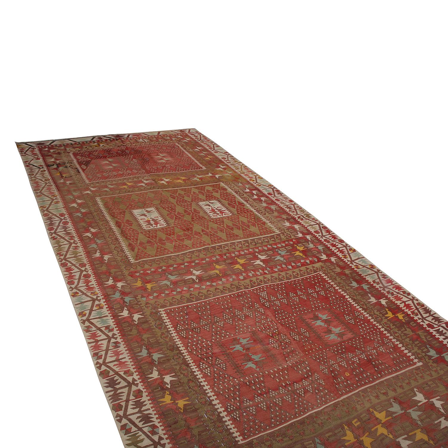 Tissé à la main en Turquie entre 1950 et 1960, ce Kilim vintage en laine de 5 x 11 provient de la ville de Kayseri, localité d'Anatolie centrale qui a inspiré le coloris traditionnel classique rouge et beige-brun de cette pièce. Ce Kilim se