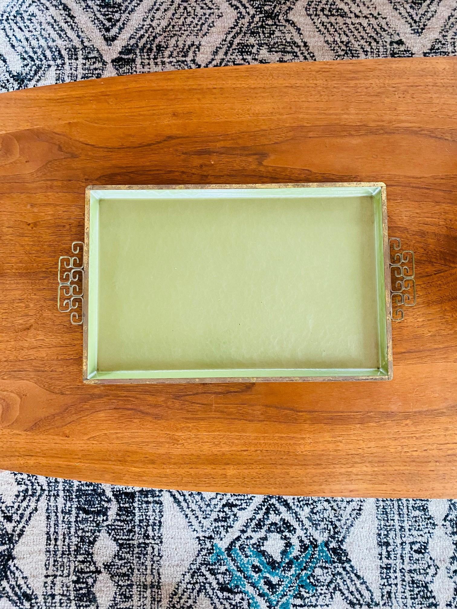 A piece of Southern California glamorous history, this vintage handmade Moire Glaze Kyes tray is composed of hammered metal with an enamel finish and double brass handles with ornate Greek key design. This beautiful piece is rectangular and with a