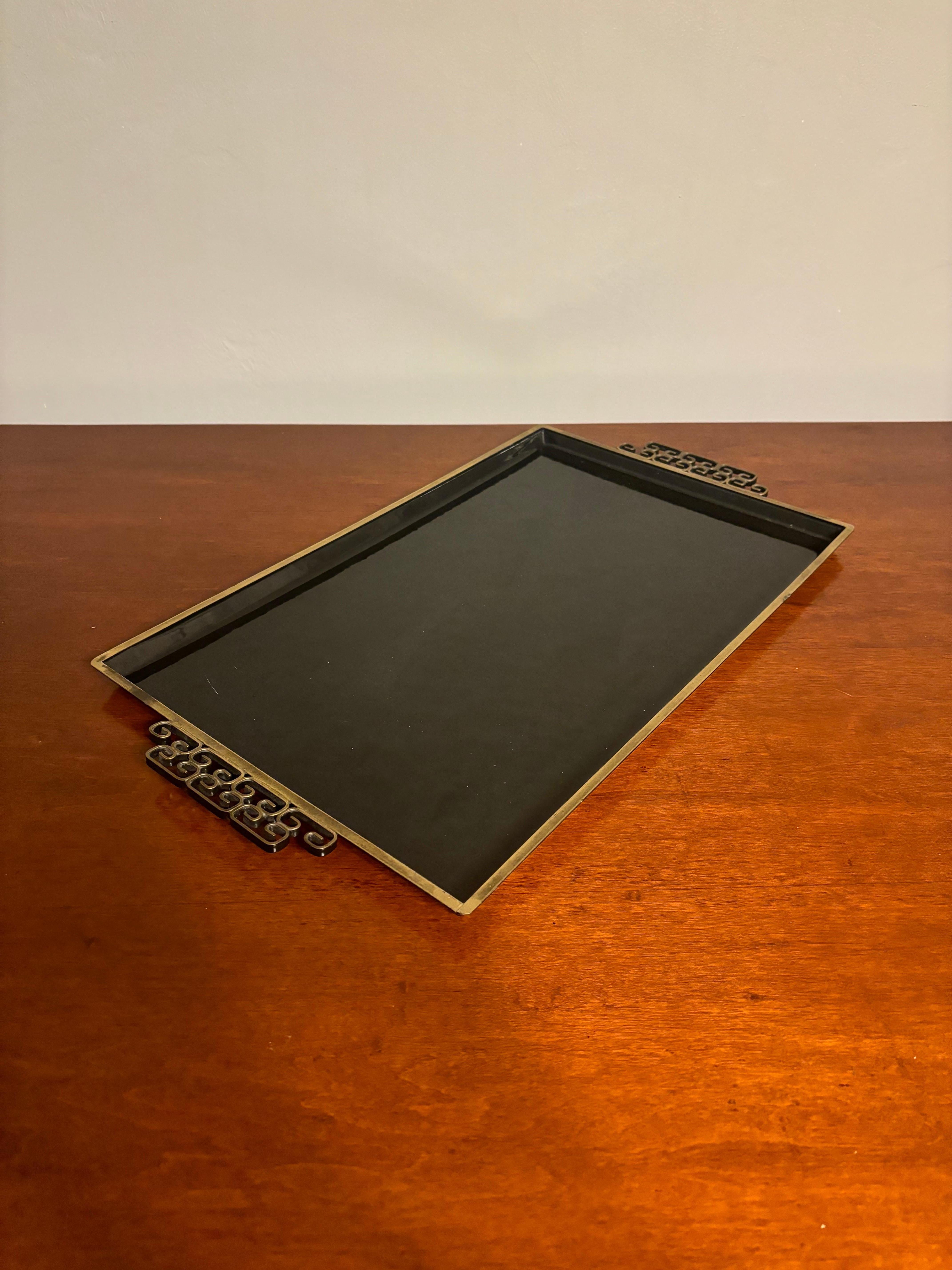 Vintage Kyes Moire serving tray. Handmade in Southern California. Composed of hammered metal with an enamel finish and double brass handles with an ornate Greek key design. Rectangular in style in a striking black color offering the ultimate