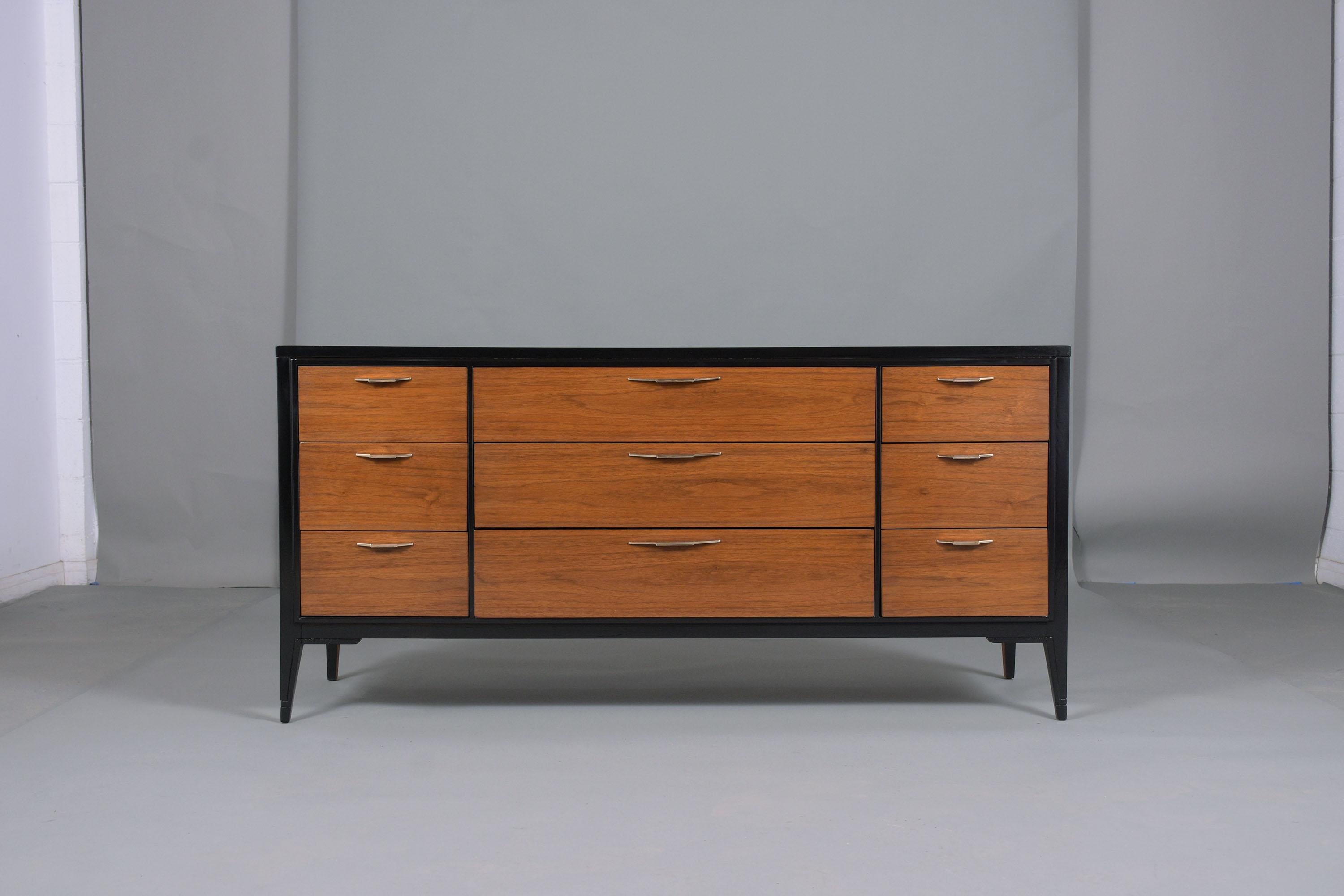 An extraordinary mid-century lacquered chest of drawers is crafted out of walnut wood and has been newly stained in a walnut & ebonized color combination with lacquered finish by our team of expert craftsmen. This dresser has nine drawers and all